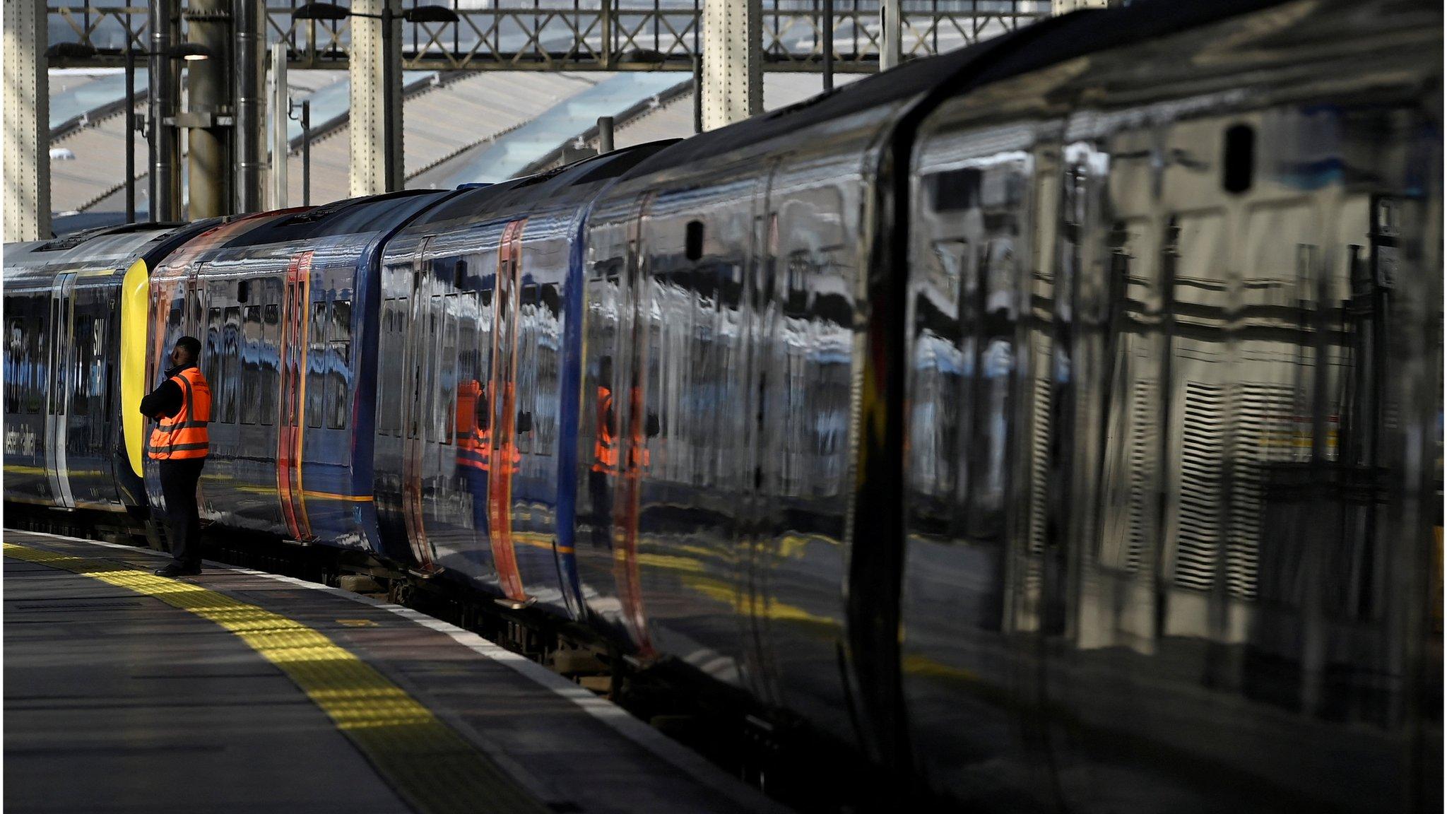 Rail employee stands beside a train