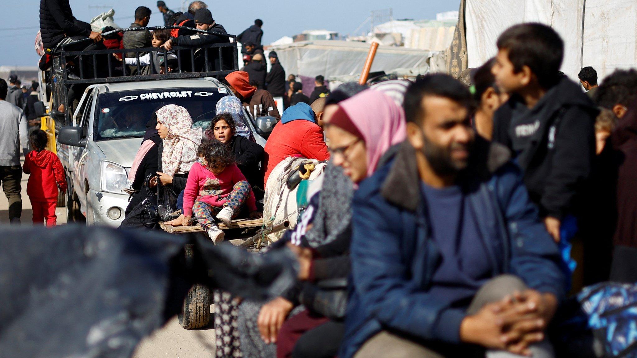 Palestinians flee the city of Khan Younis on pick-up trucks and horse-drawn carts amid intense fighting in the southern Gaza Strip (22 January 2024)