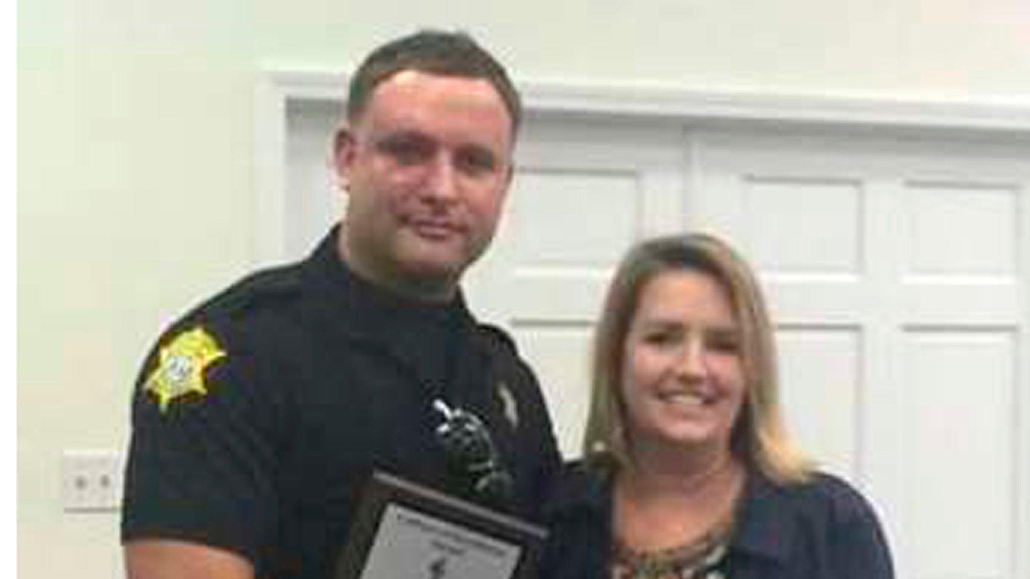 Richland County Sheriff's Department Officer Senior Deputy Ben Fields is pictured with Karen Beaman (R), Principal of Lonnie B Nelson Elementary School, after receiving an excellence award at the school in Columbia, South Carolina, on 2 November 2014