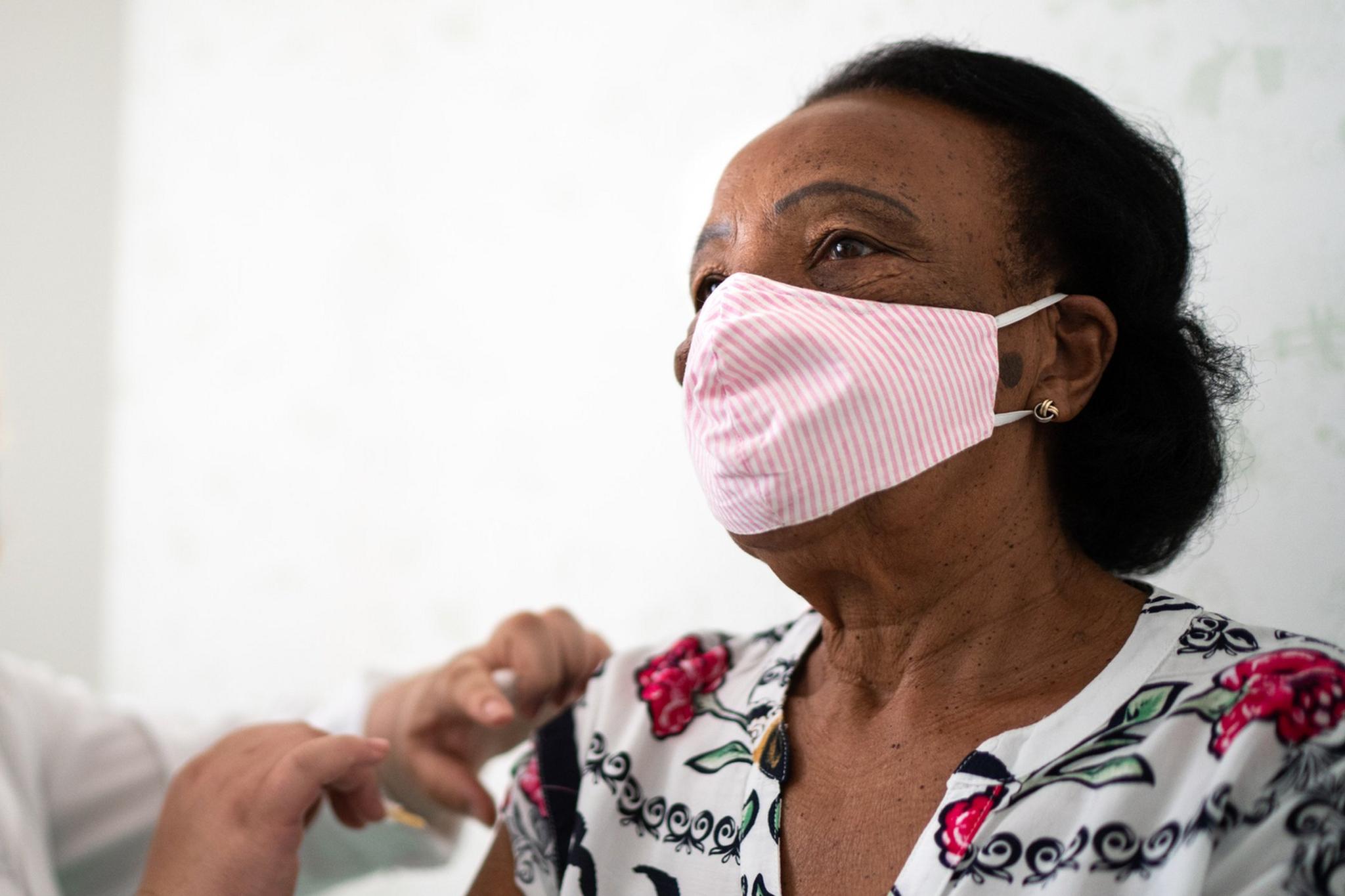 A black woman receiving a jab in her arm.