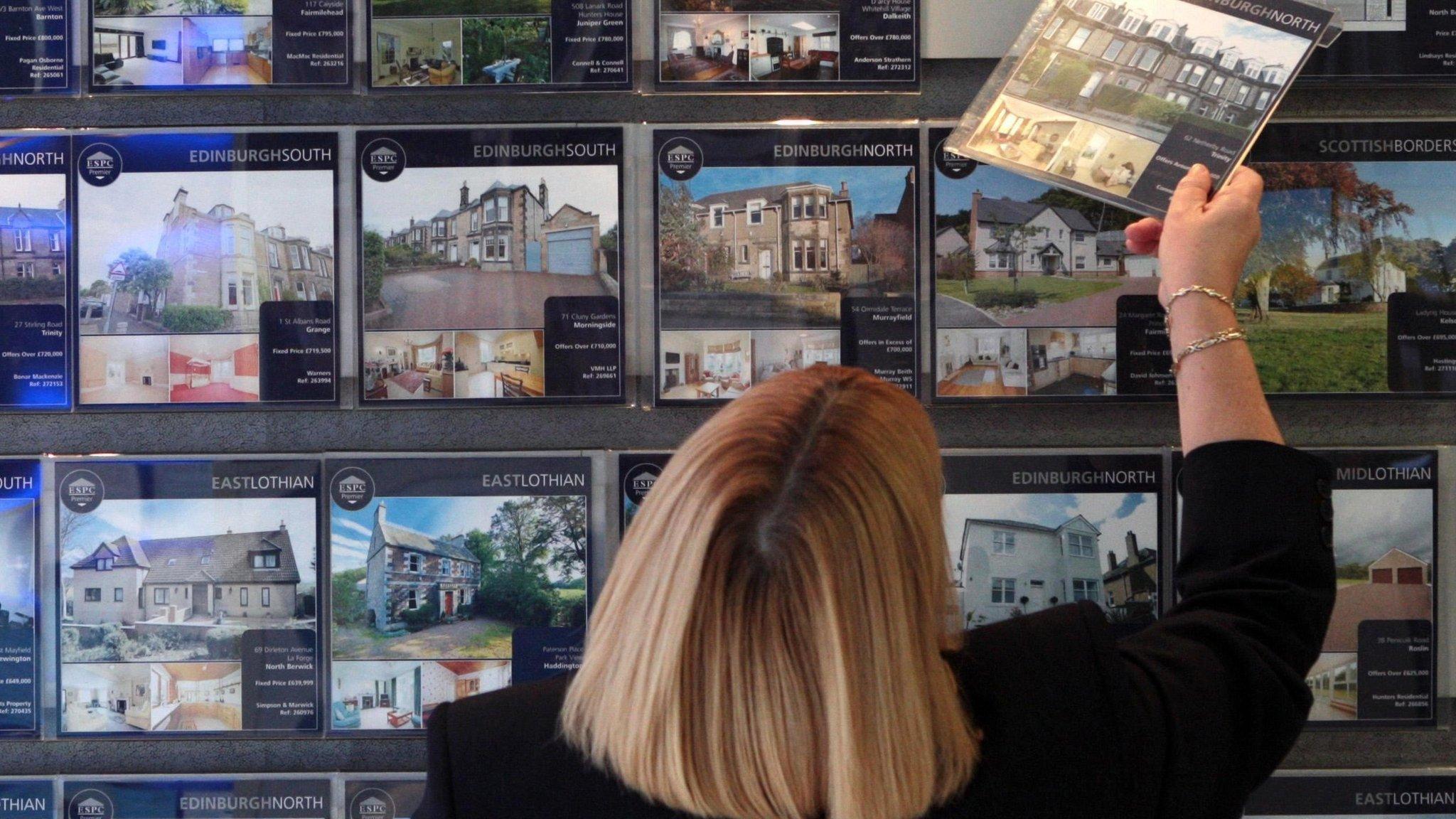 Woman looking in estate agent window