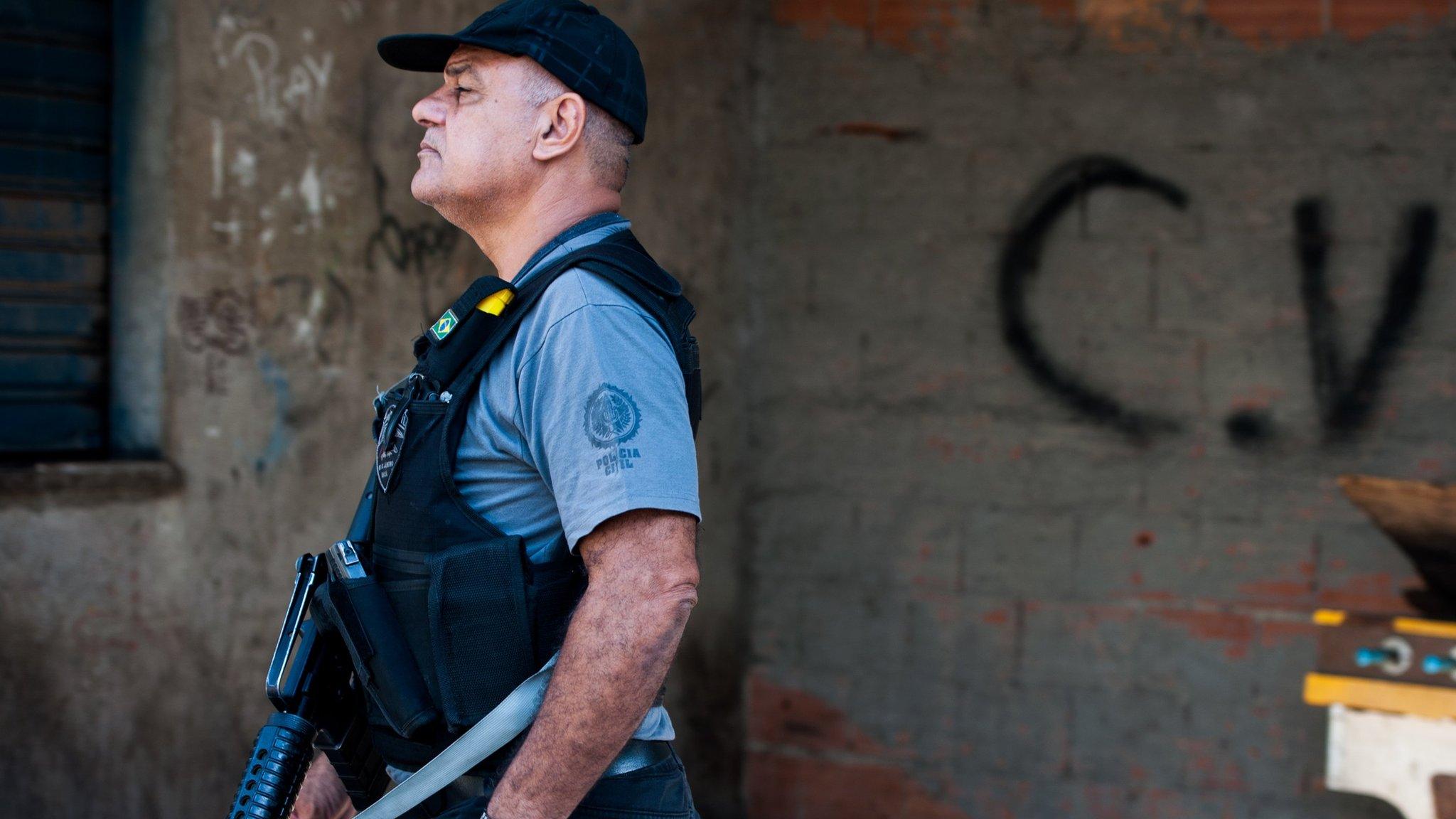 : A Brazilian military police patrol with the symbol at the bottom of the criminal group Comando Vermelho after entering the unpacified Complexo da Mare, one of the largest 'favela' complexes in Rio, on March 30, 2014 in Rio de Janeiro, Brazil.