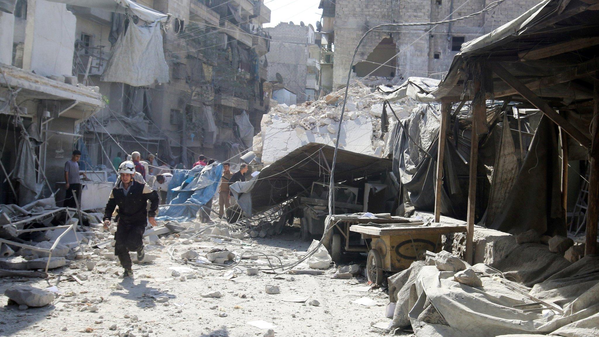 A rescue worker runs at a market hit by air strikes in Aleppo's rebel-held Fardous district, Syria (12 October 2016)