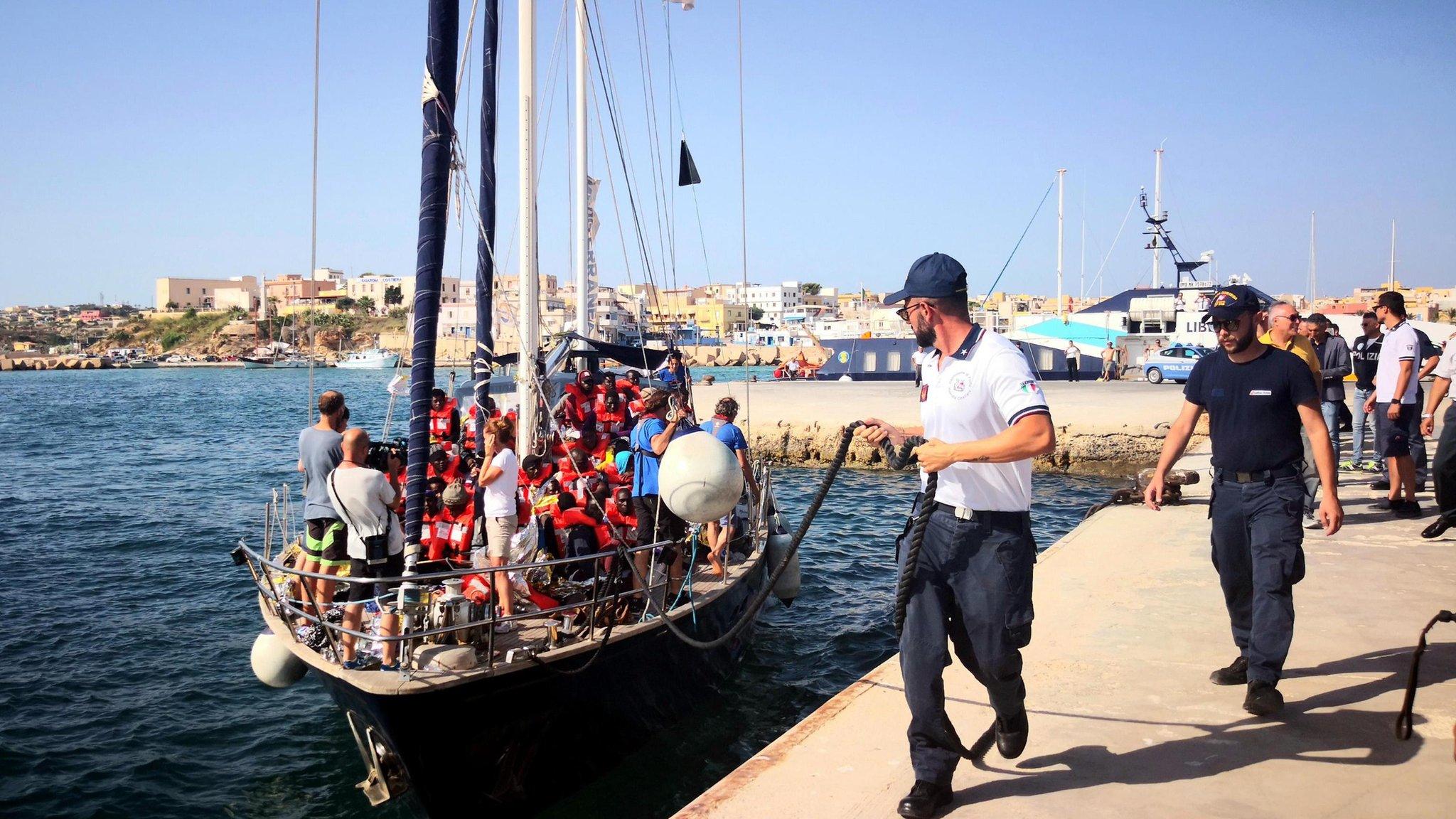 A man brings the Alex migrant ship to shore in Lampedusa, Italy