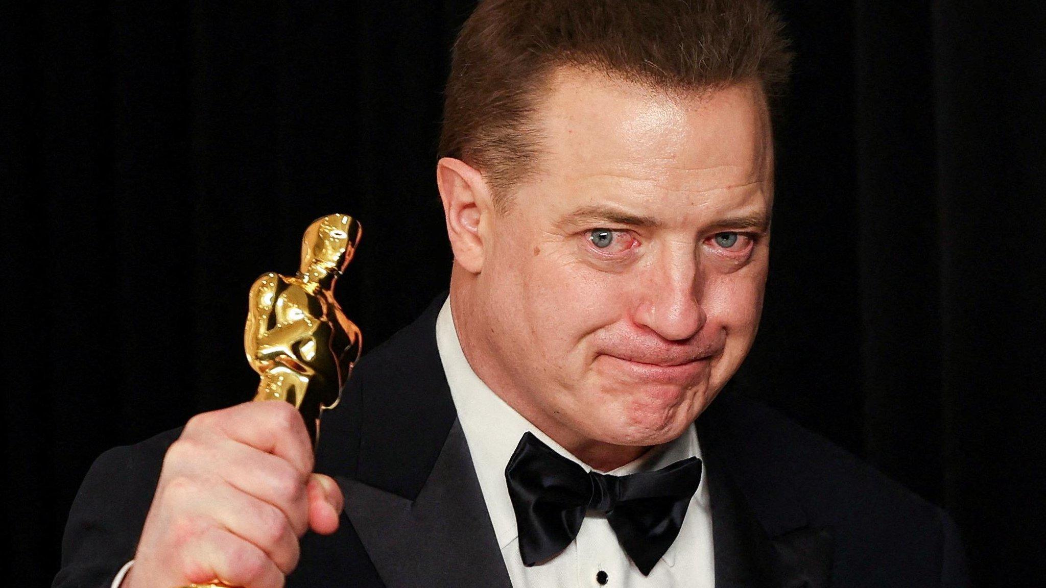 Brendan Fraser holding his Oscar up