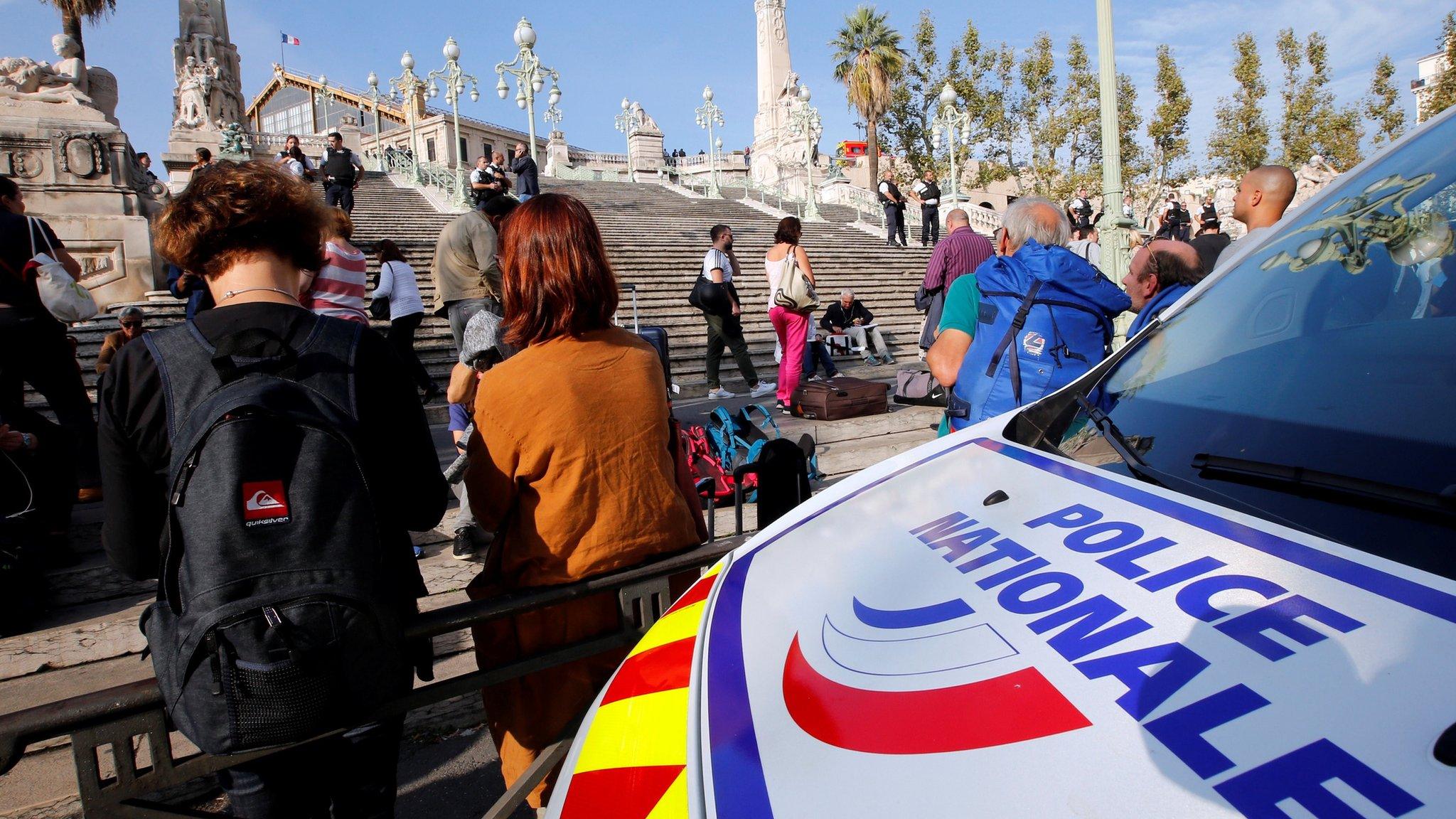 Travellers gather at the steps outside Marseille train station, in front of a police van (1 October 2017)