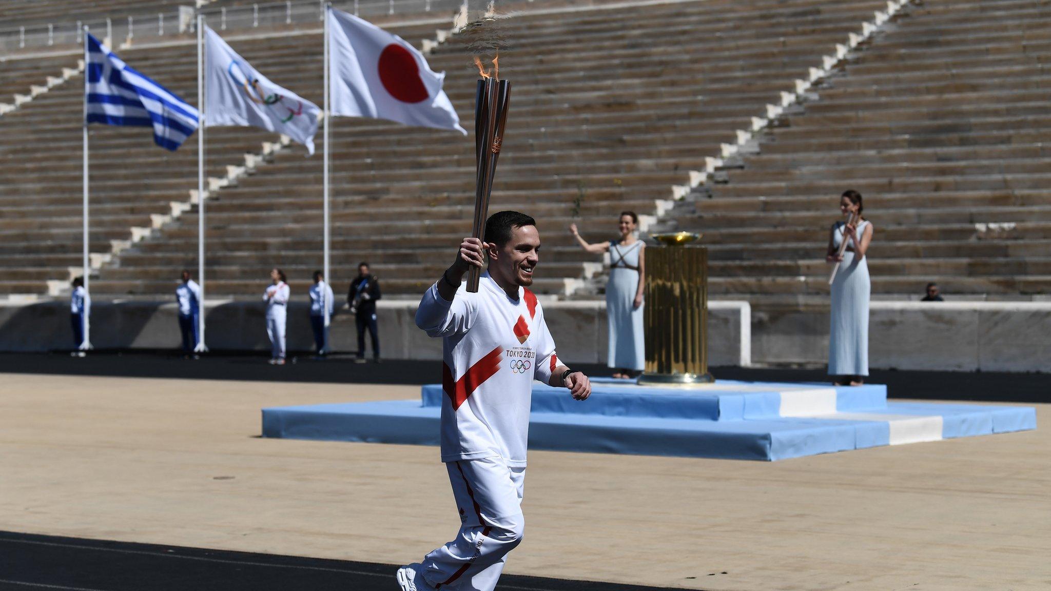 An athlete carries the Olympic flame