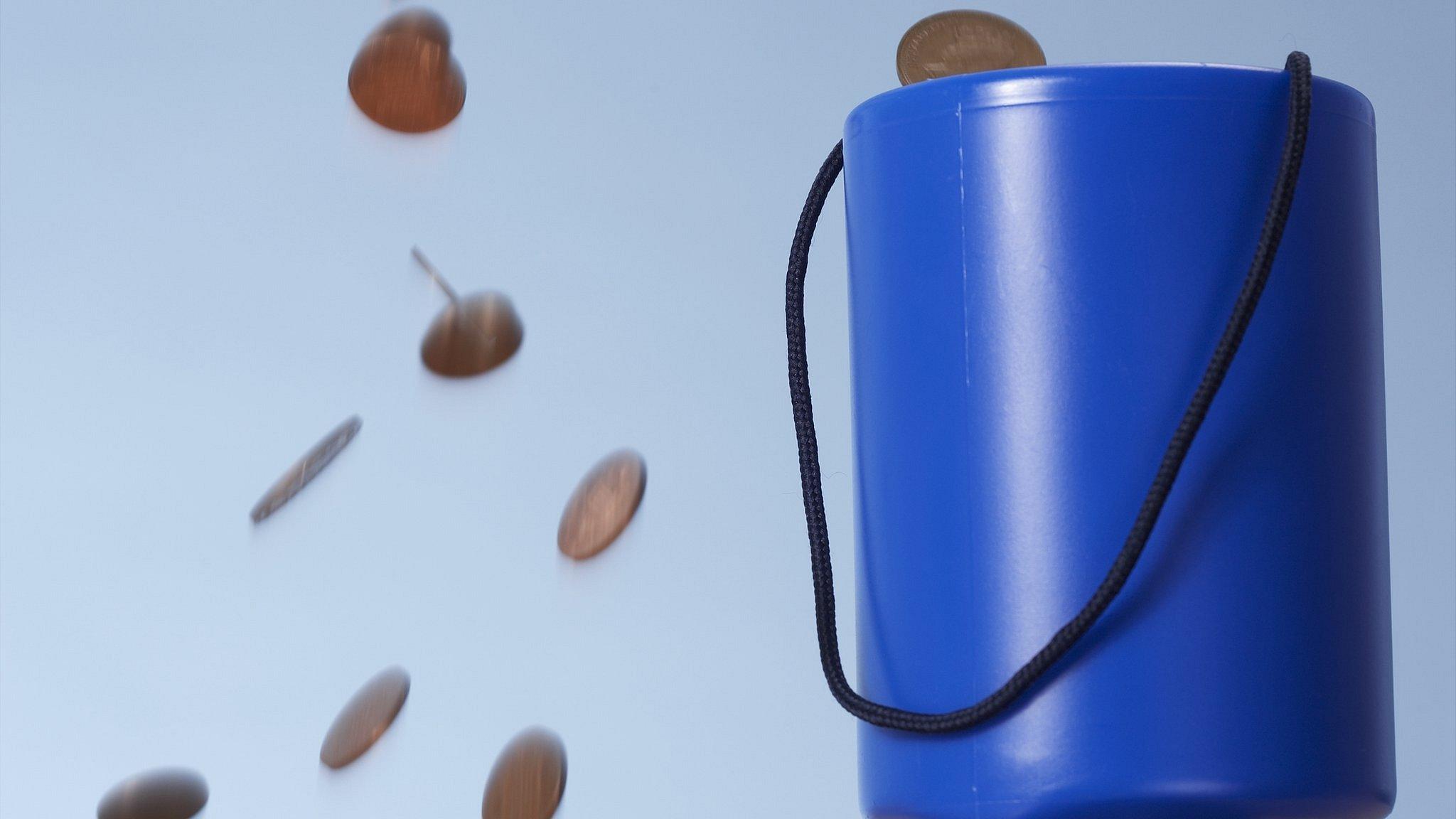 Coins falling and charity collection box