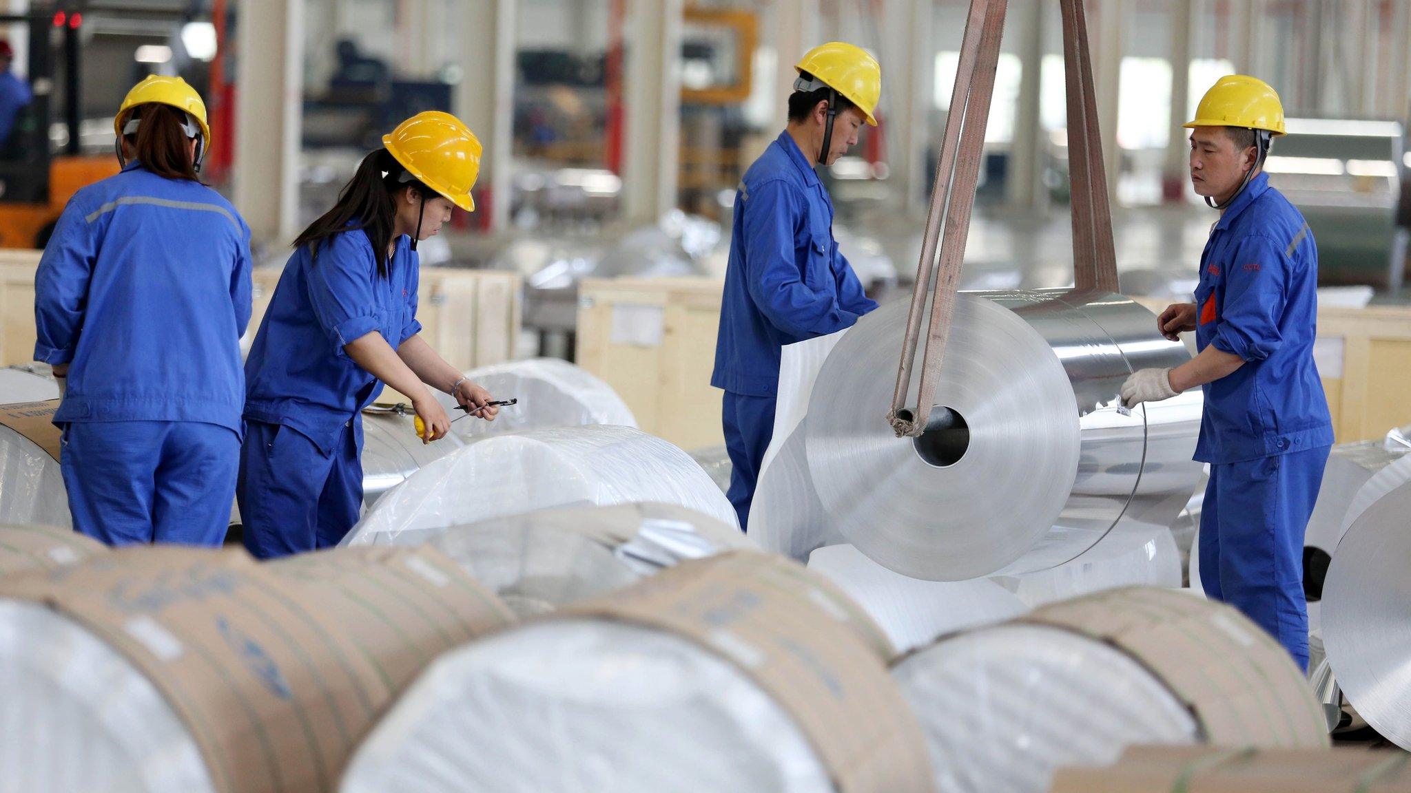 Chinese workers packaging aluminium tapes at an aluminium production plant in Huaibei, east China's Anhui province