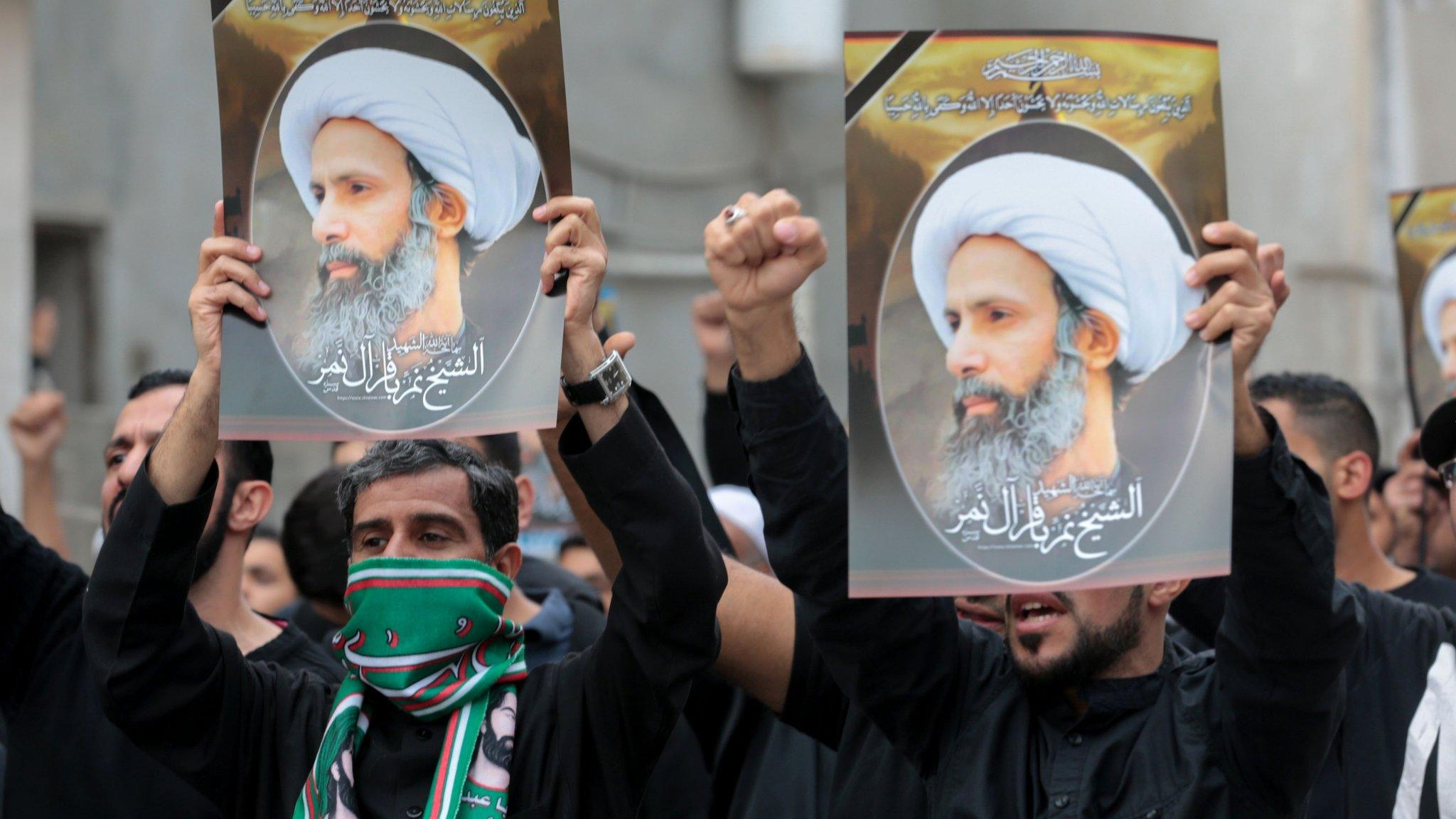 Protesters hold up posters showing the executed Shia cleric Sheikh Nimr al-Nimr at a protest in Qatif, Saudi Arabia (8 January 2016)