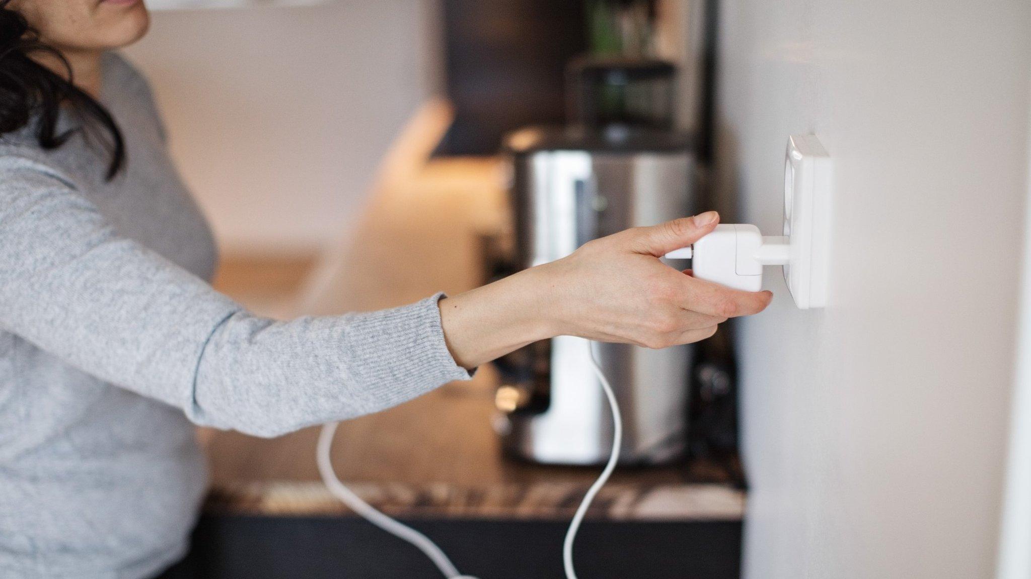 woman unplugging electrical device