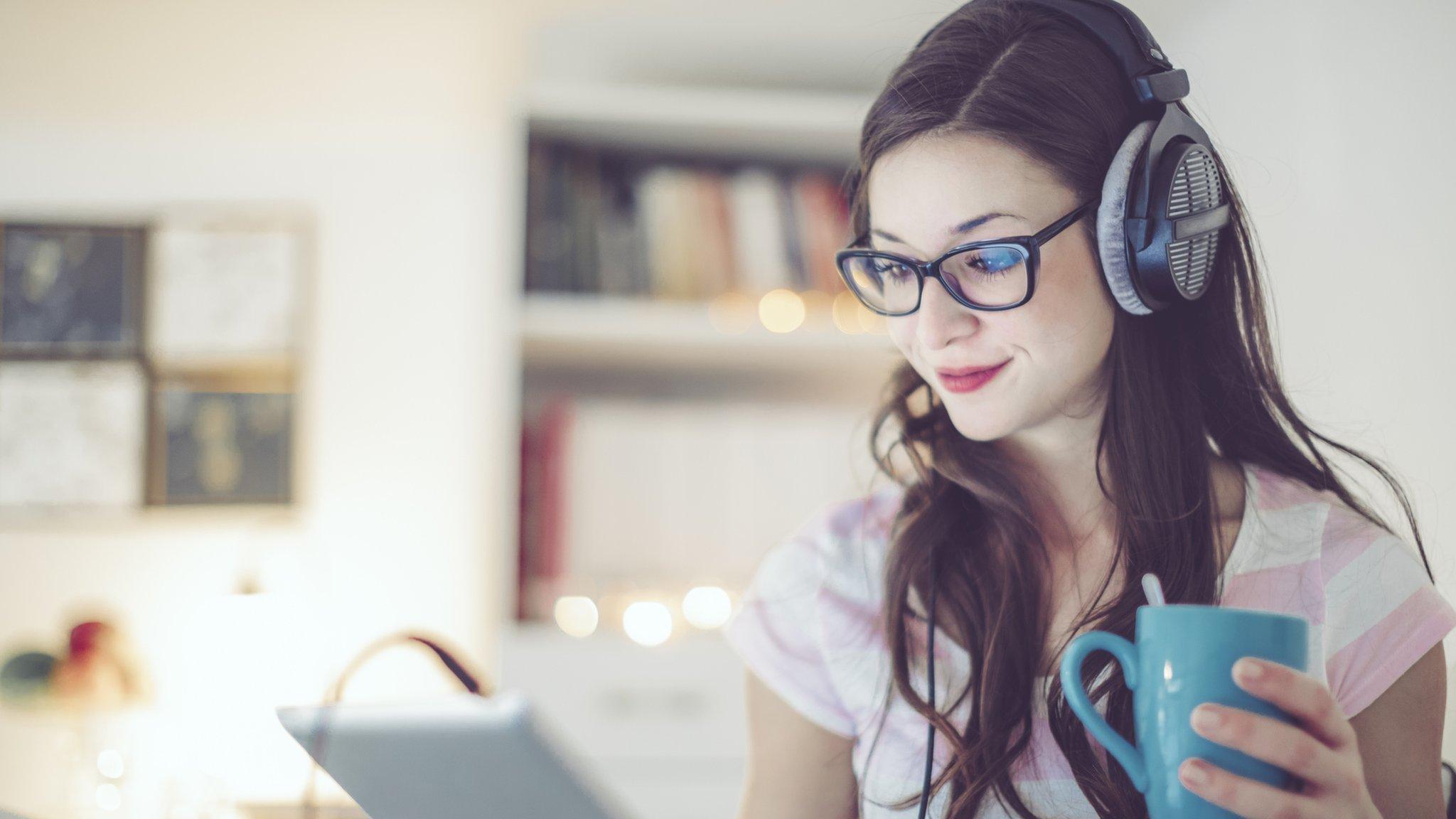 girl with headphones looking at tablet