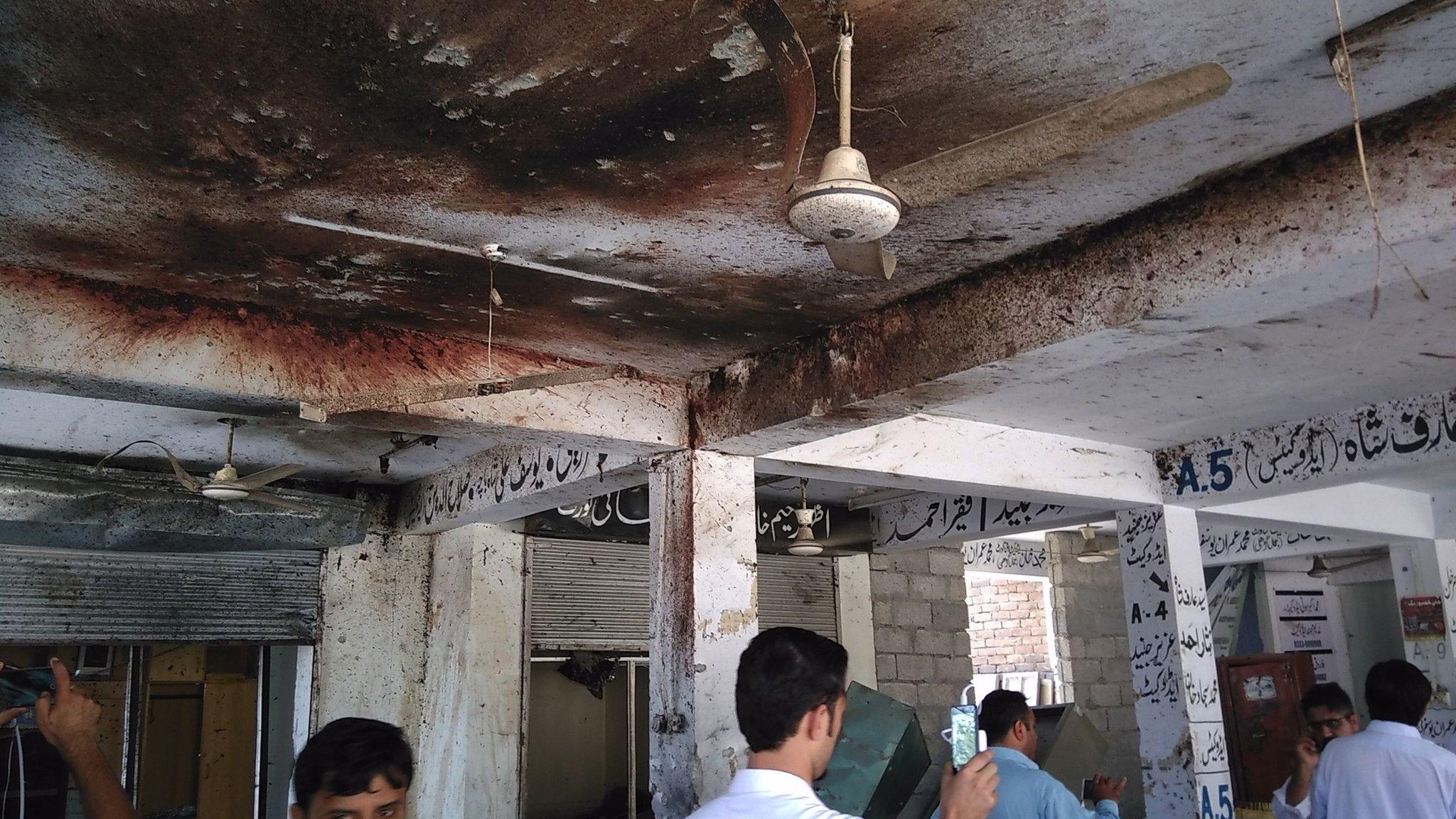 Pakistani local residents inspect the site of a suicide bomb attack at a district court in Mardan on September 2, 2016