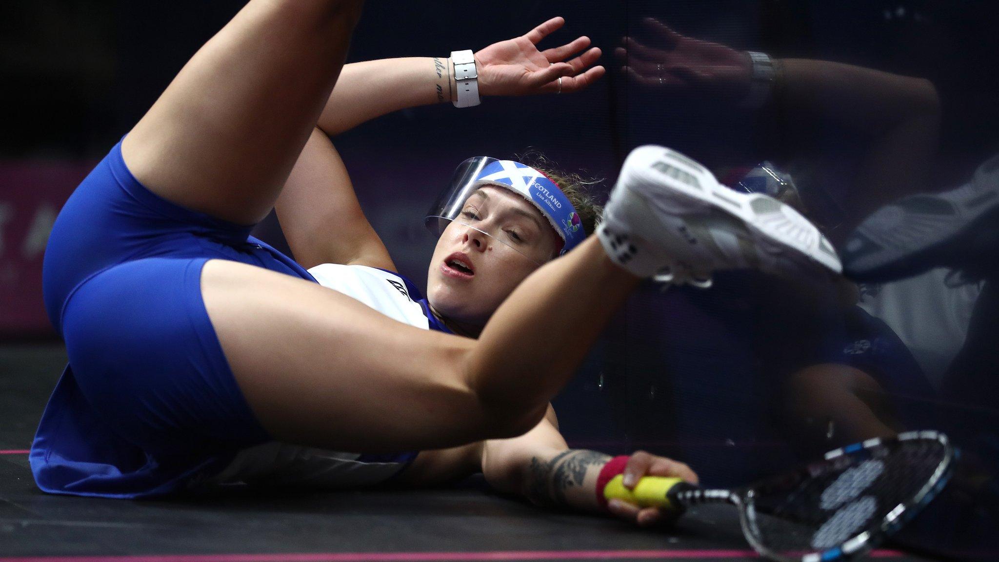 Lisa Aitken crashes into the wall during her women's squash doubles match with team-mate Alison Thomson of Scotland against Sarah-Jane Perry and Laura Massaro of England