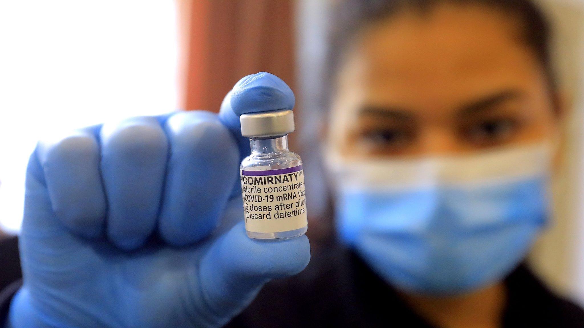 Vaccine worker with vial of vaccine in Romania