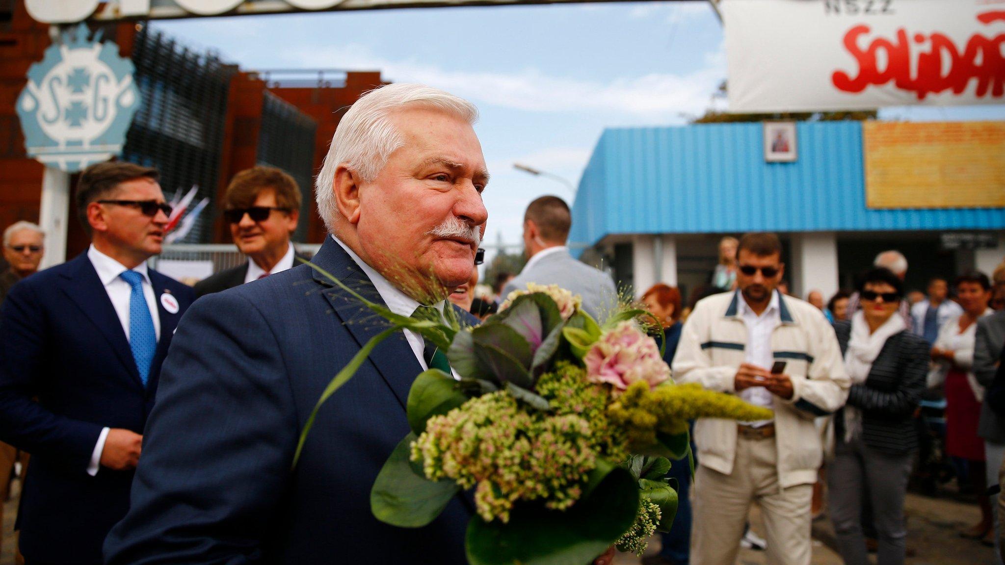 Lech Walesa walks with flowers during Solidarity's 34th anniversary in front of the gate to the historic shipyard in Gdansk, Poland (31 August 2014)