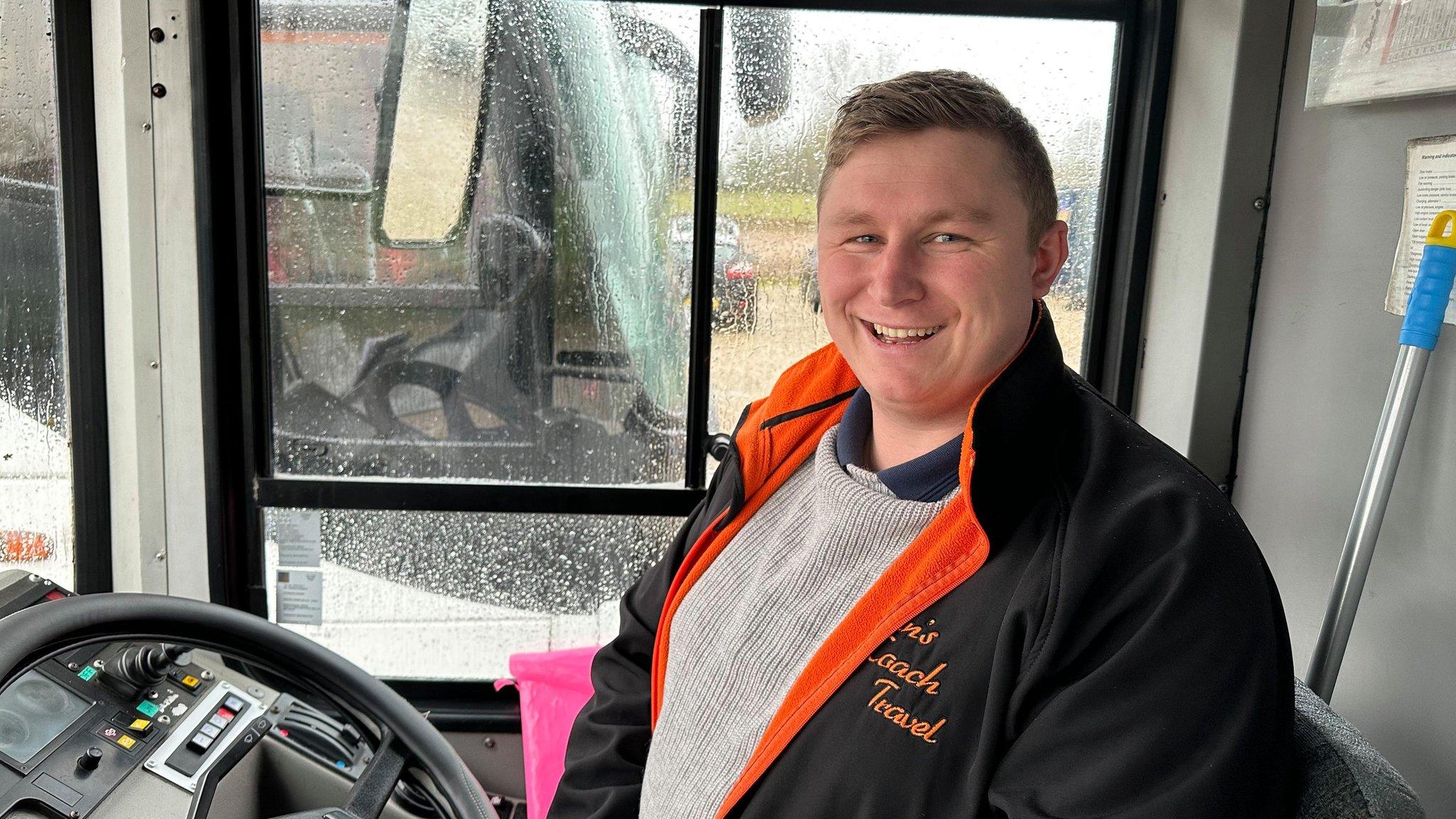 The owner of Dan's Coach Travel, Dan Trent sitting on a bus