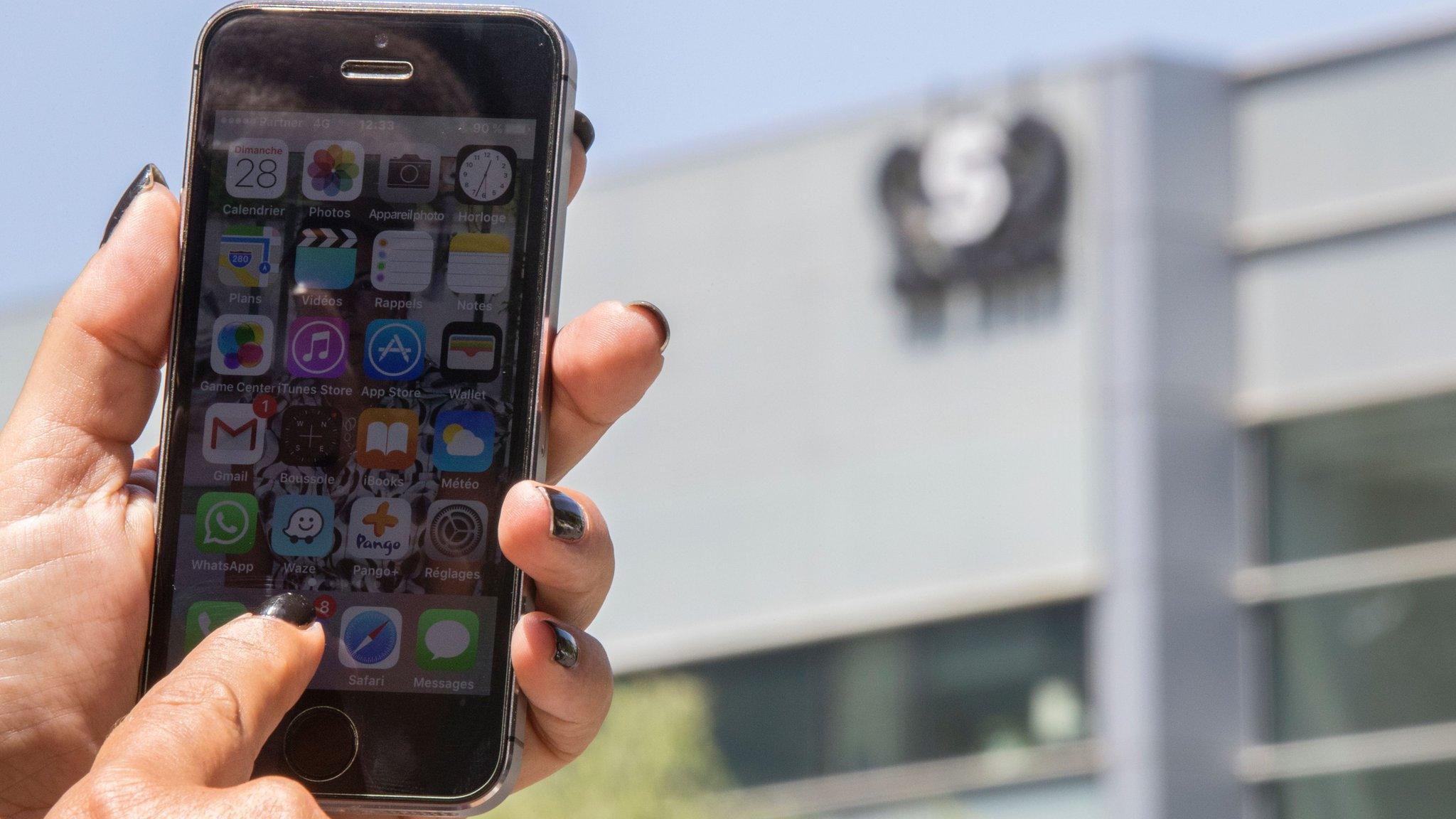 An Israeli woman uses her iPhone in front of the building housing the Israeli NSO group, on August 28, 2016, in Herzliya, near Tel Aviv