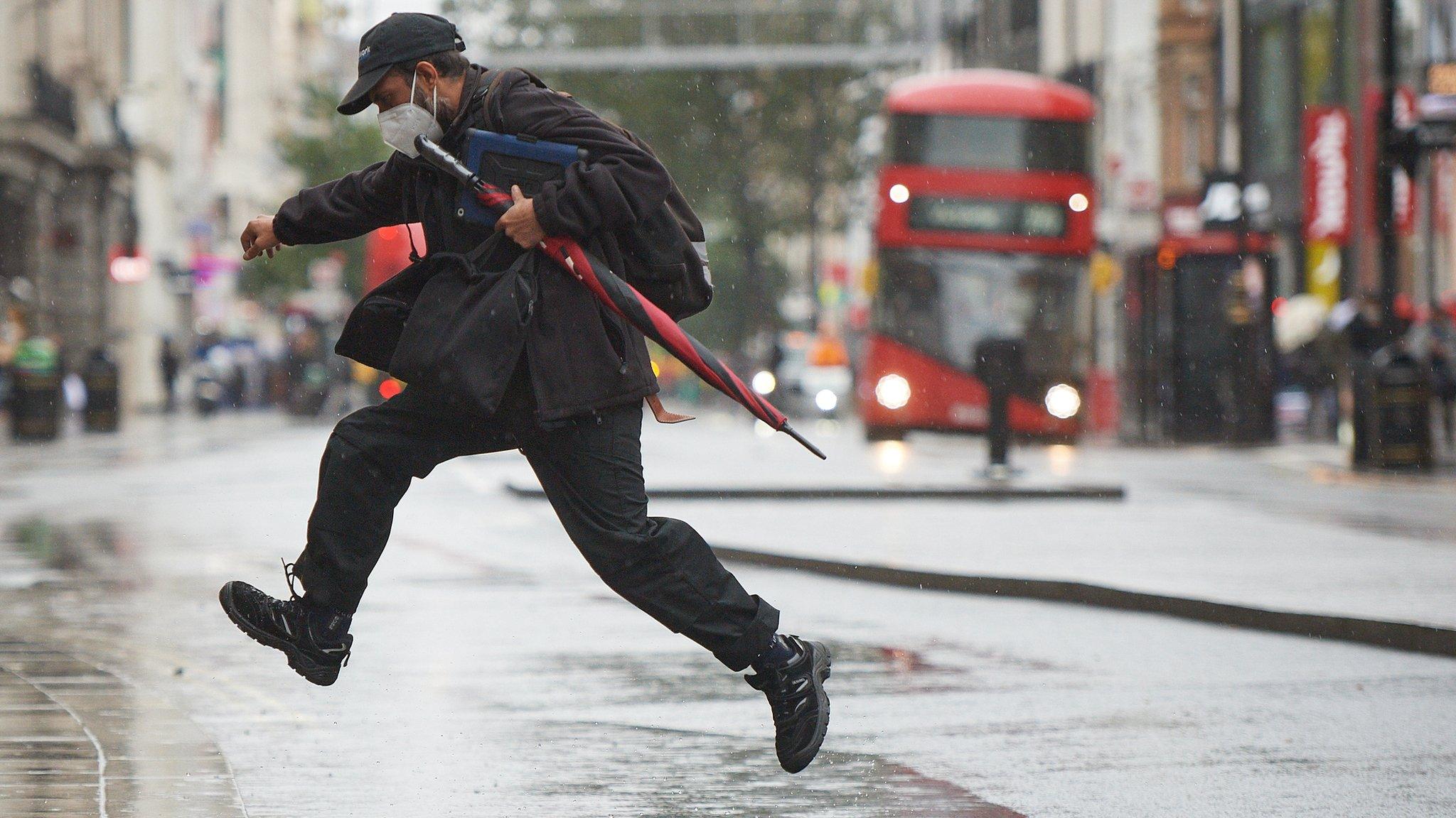 Man-jumps-over-puddle-in-London.
