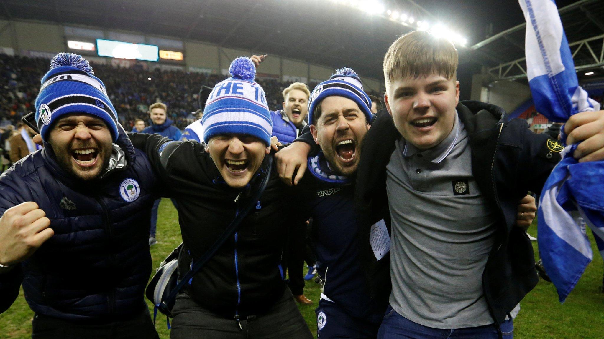 Wigan fans celebrate their victory over Manchester City