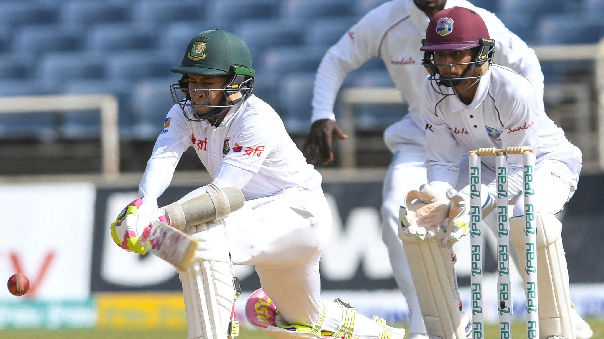 Bangladesh's Mushfiqur Rahim reverse-sweeps, watched by West Indies keeper Shane Dowrich