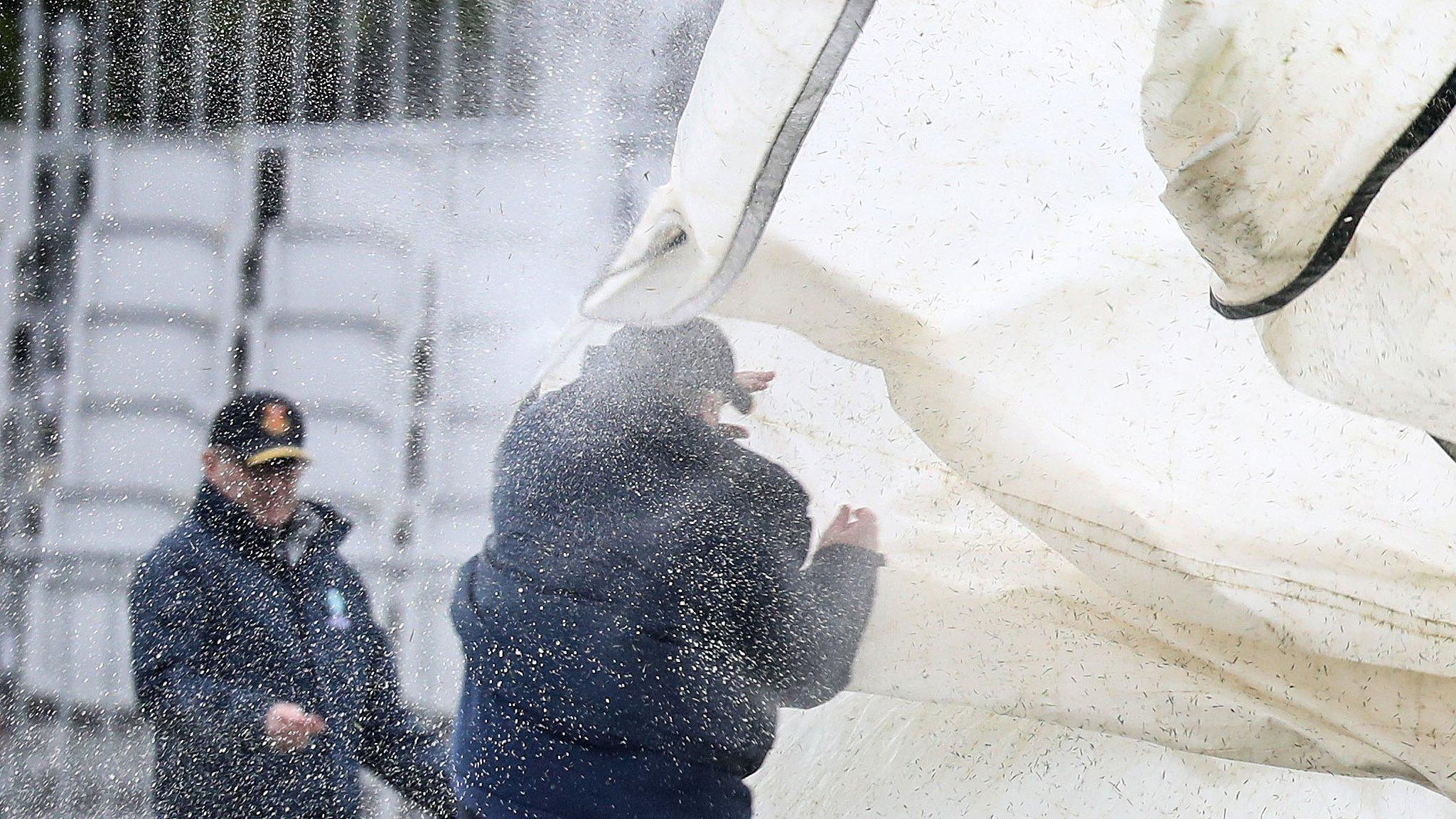 Stewards struggle in the windy conditions at Malahide Cricket Club