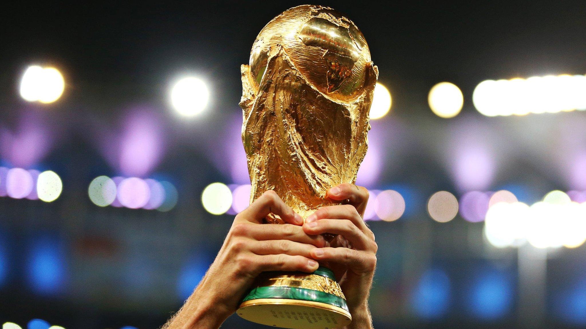 A player lifting the FIFA World Cup Trophy