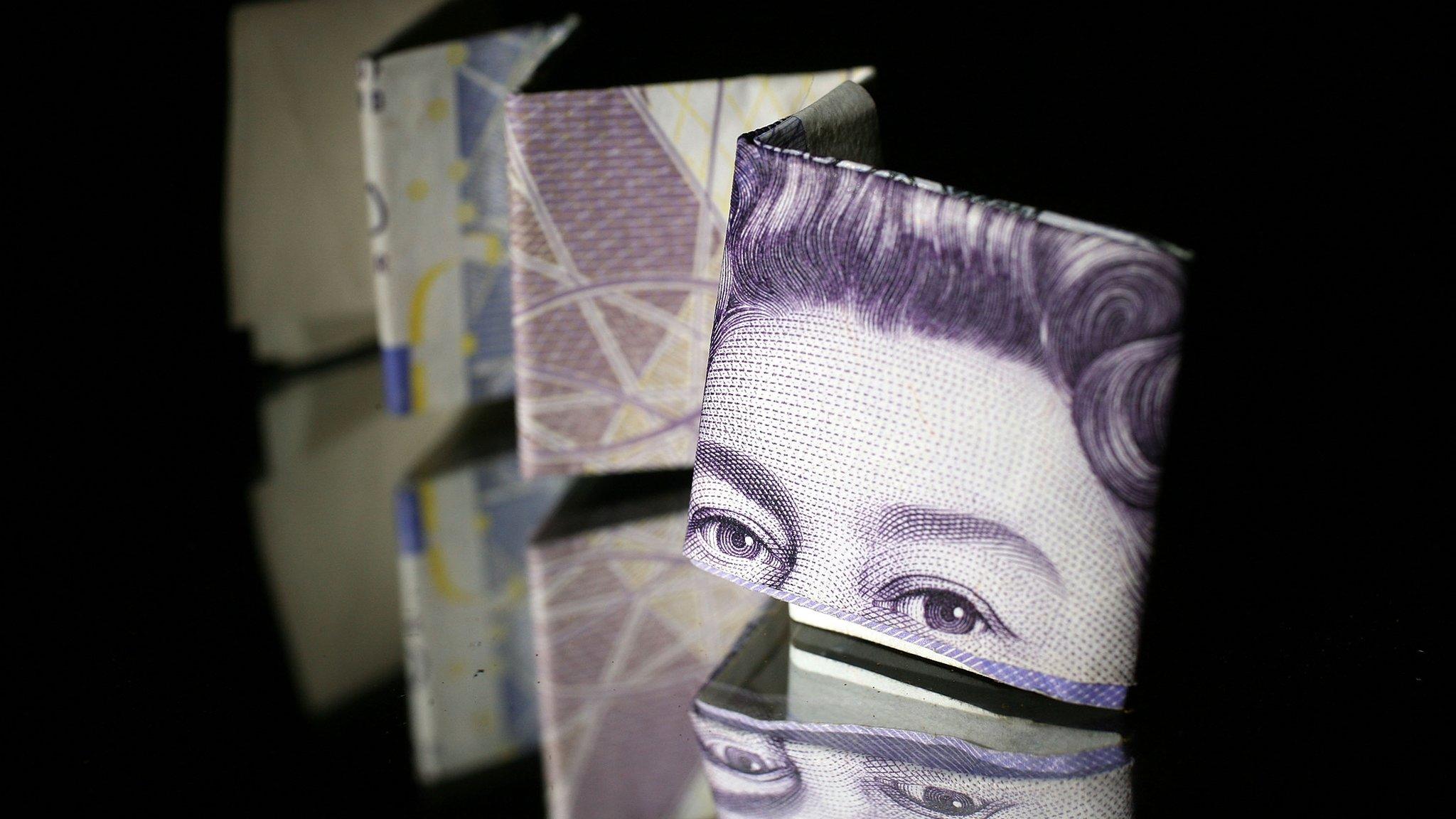 A photo illustration of a British 20 pound note reflected in glass