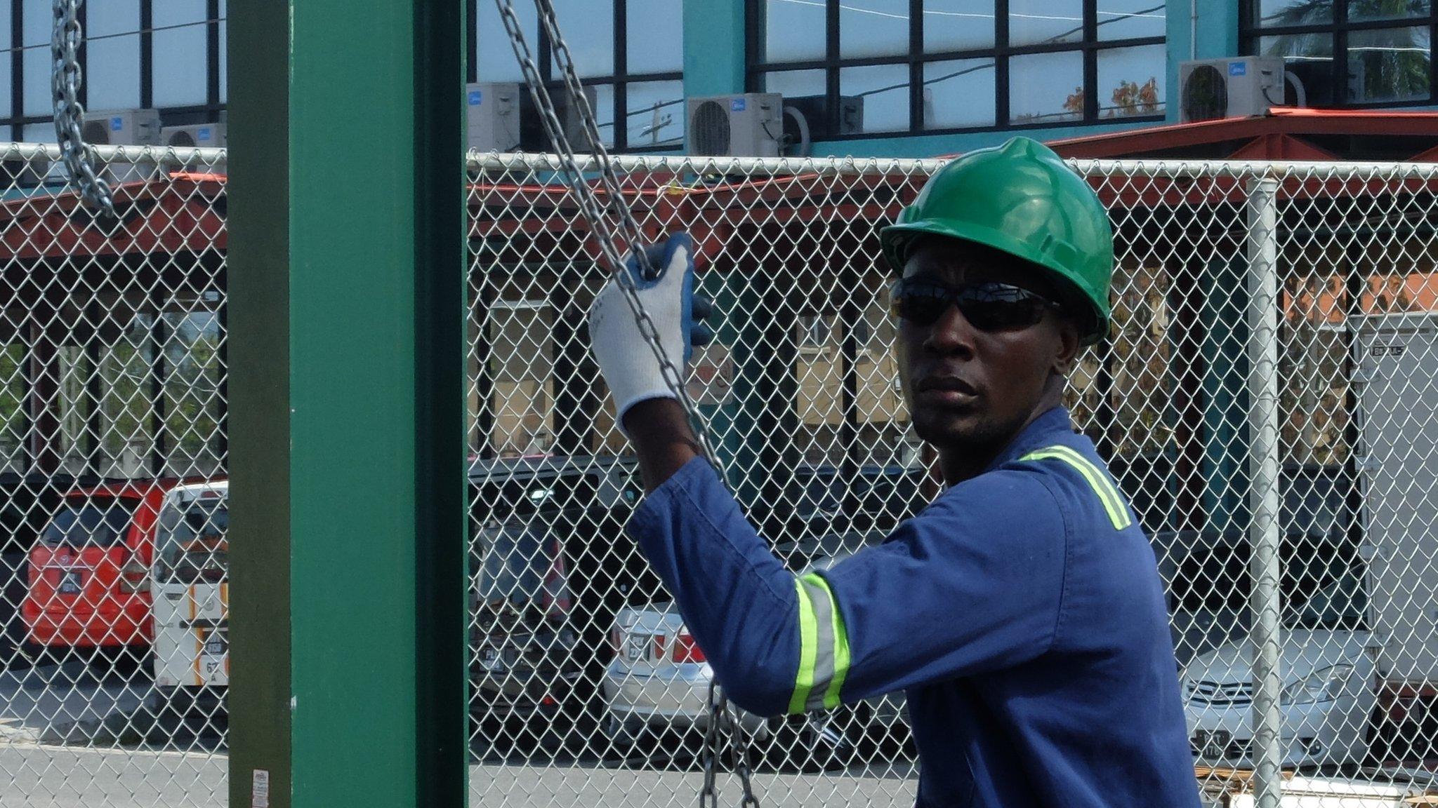 A man working in the oil industry in Guyana helps get equipment into place