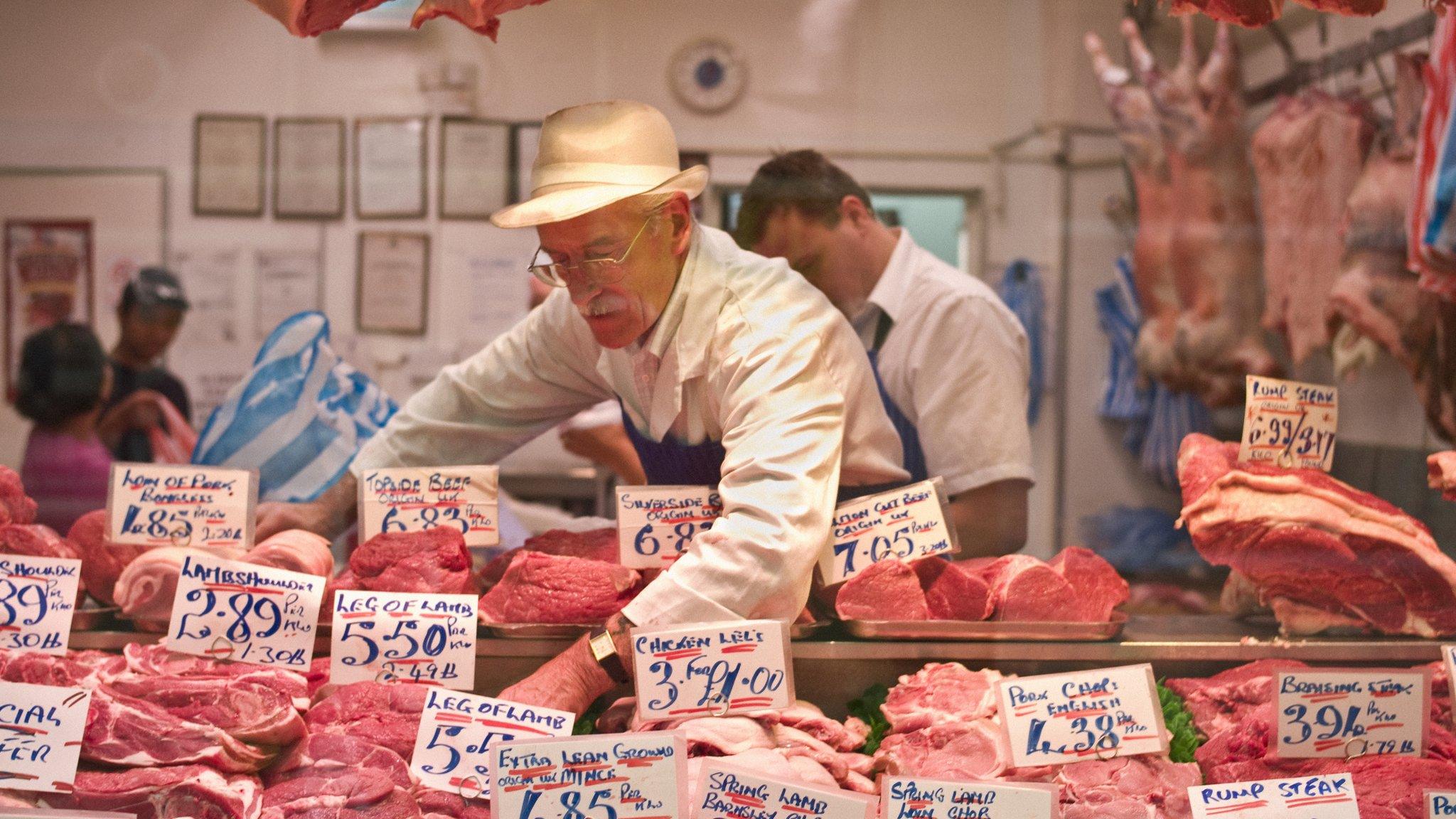 Butchers rearranging meat