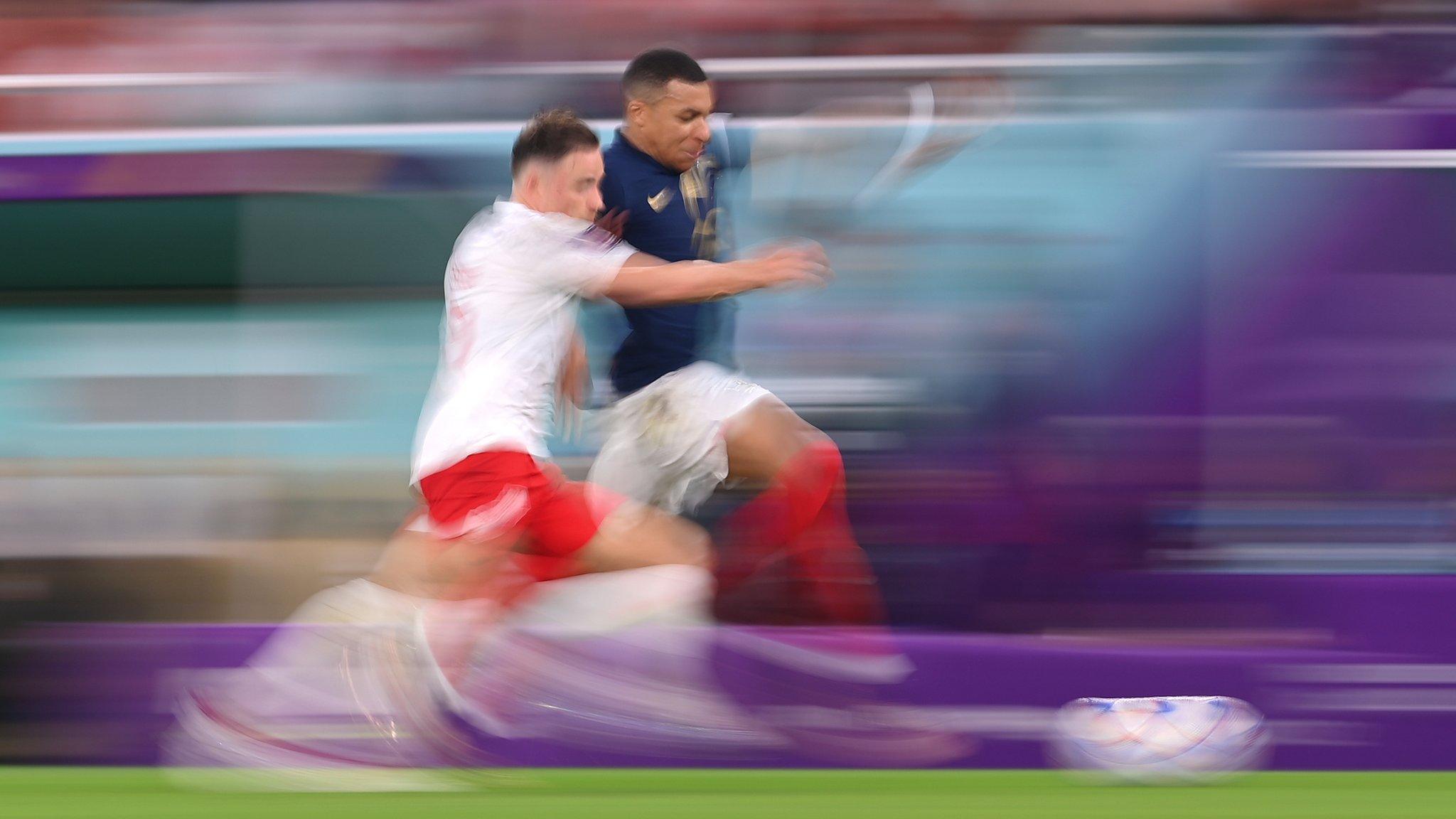 Kylian Mbappe and Matty Cash sprinting along the touchline - the blurred picture suggesting how fast they are running