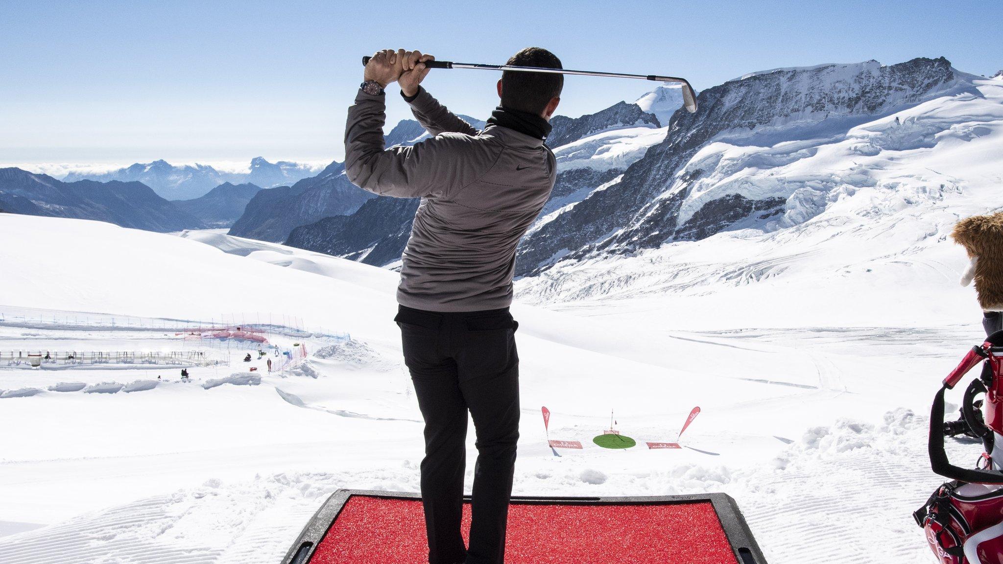 Jungfraujoch, Switzerland, 4 October: Rory McIlroy plays a shot during a golf event on the Aletsch glacier. (Photo by Anthony Anex/EPA)