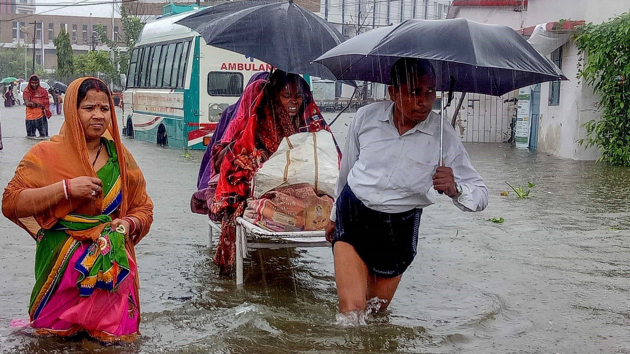 Patients wade through floodwaters