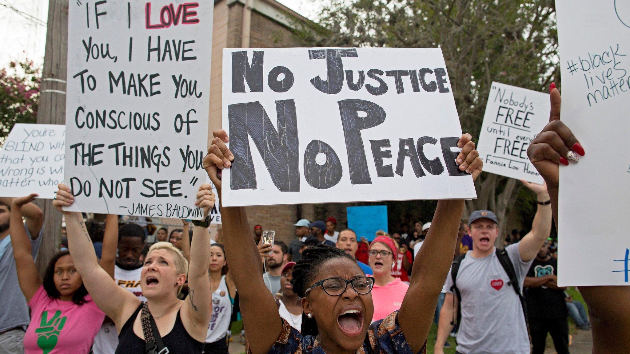 Police and protesters demonstrate in a residential neighborhood in Baton Rouge, La. on Sunday, July 10, 2016.