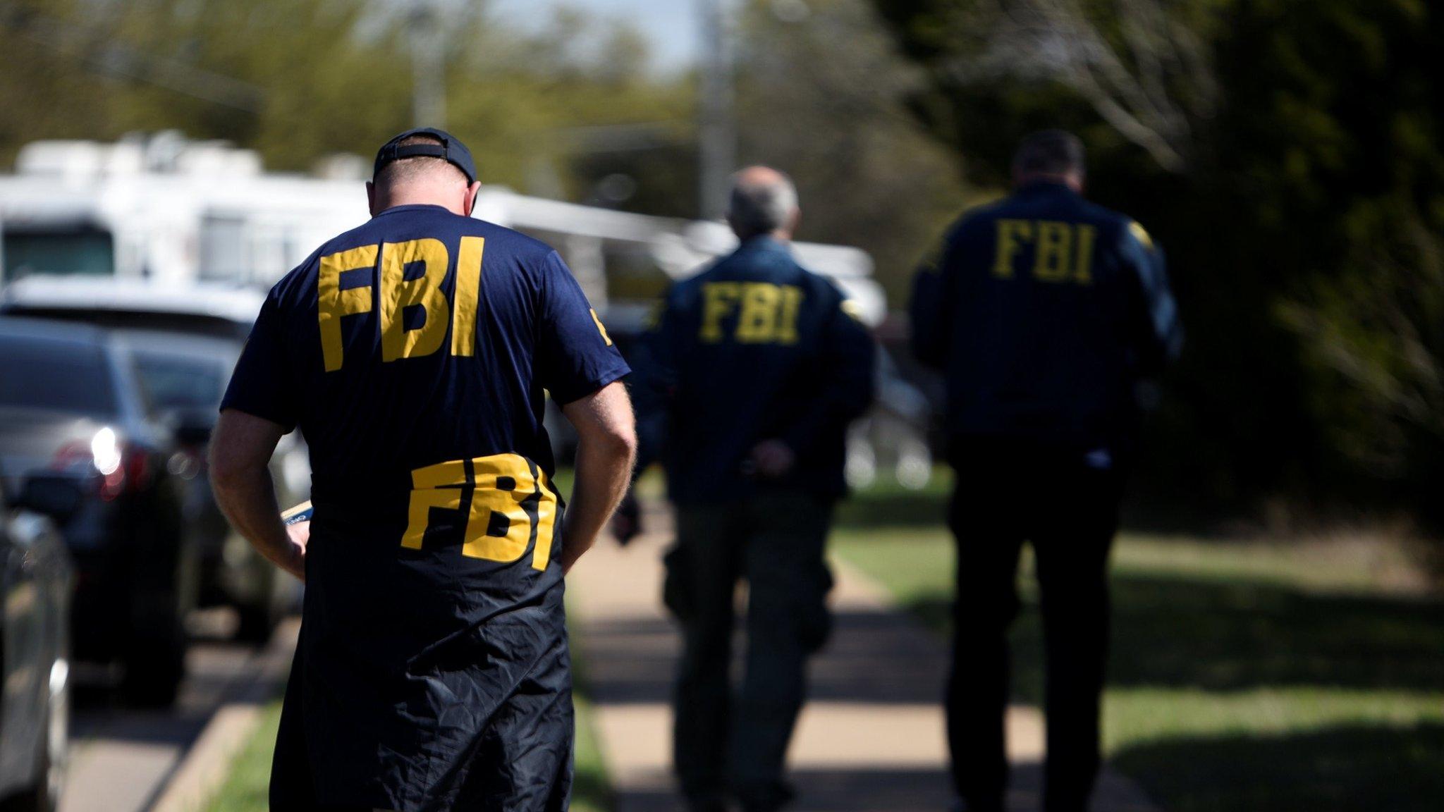 FBI agents walk towards a crime scene on Mission Oaks Boulevard following an explosion in Austin, Texas, U.S., March 19, 2018.