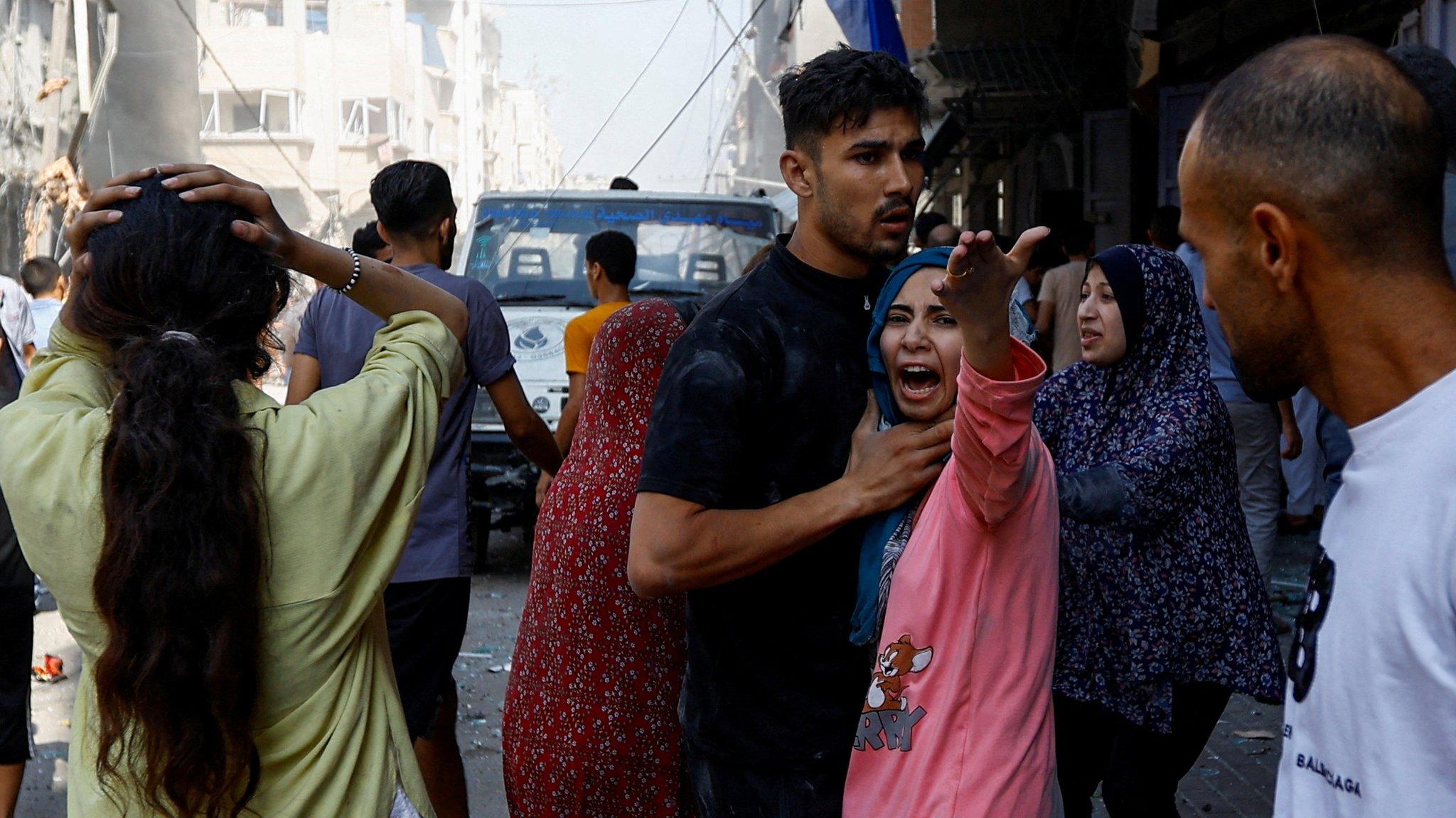 Palestinians react at the scene of an Israeli strike in Khan Younis, in the southern Gaza Strip (24 October 2023)