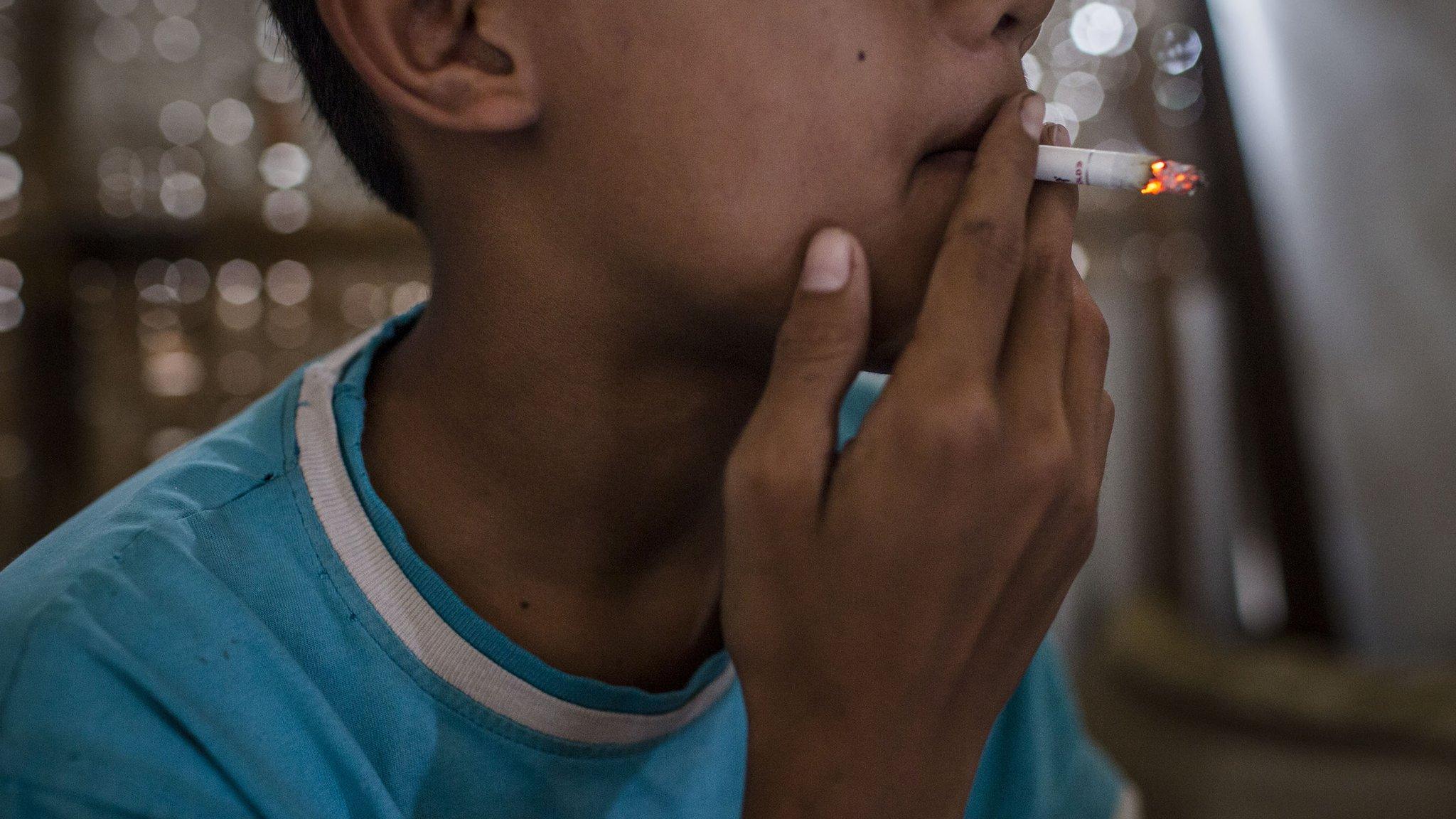 Teenager smokes at a kiosk on March 6, 2017 in Yogyakarta, Indonesia