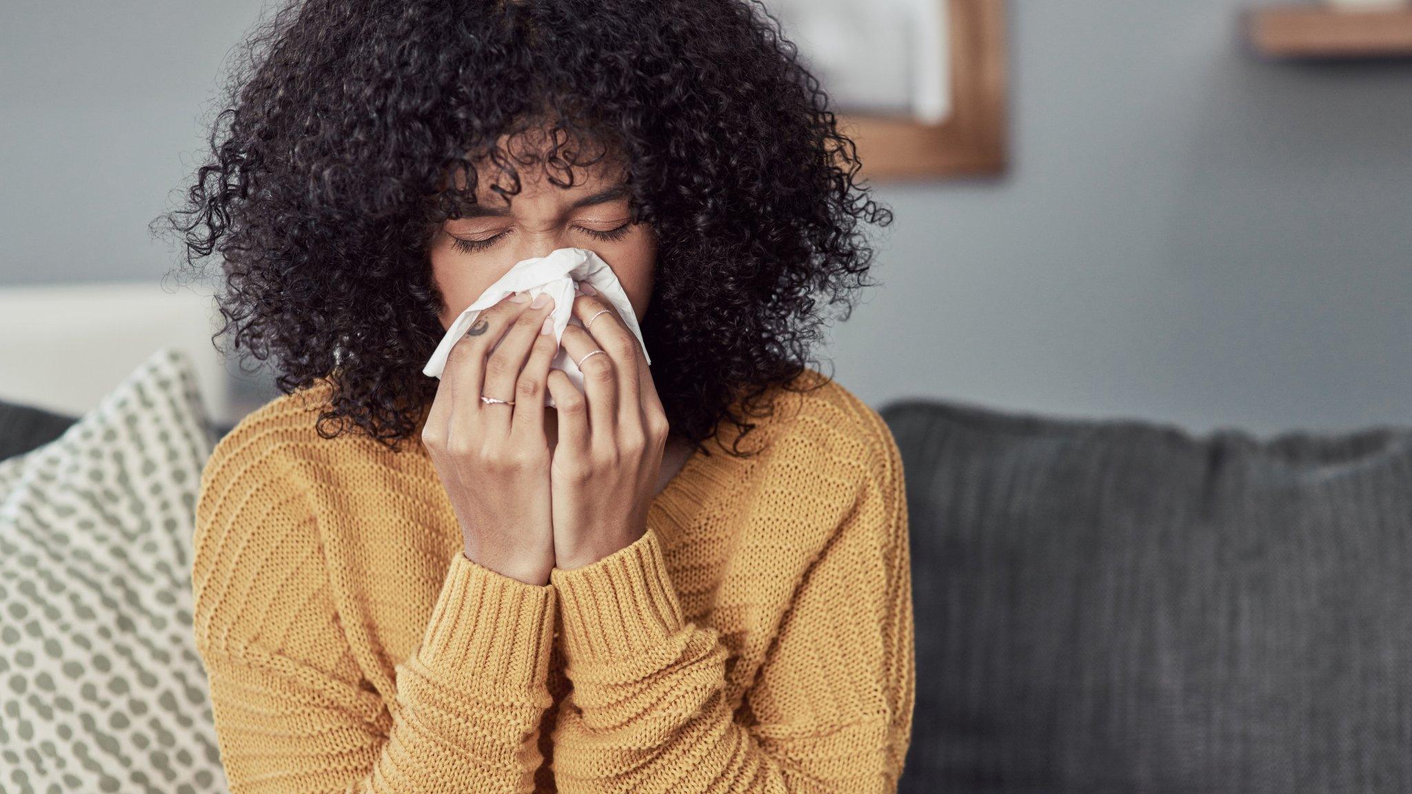 A woman blows her nose