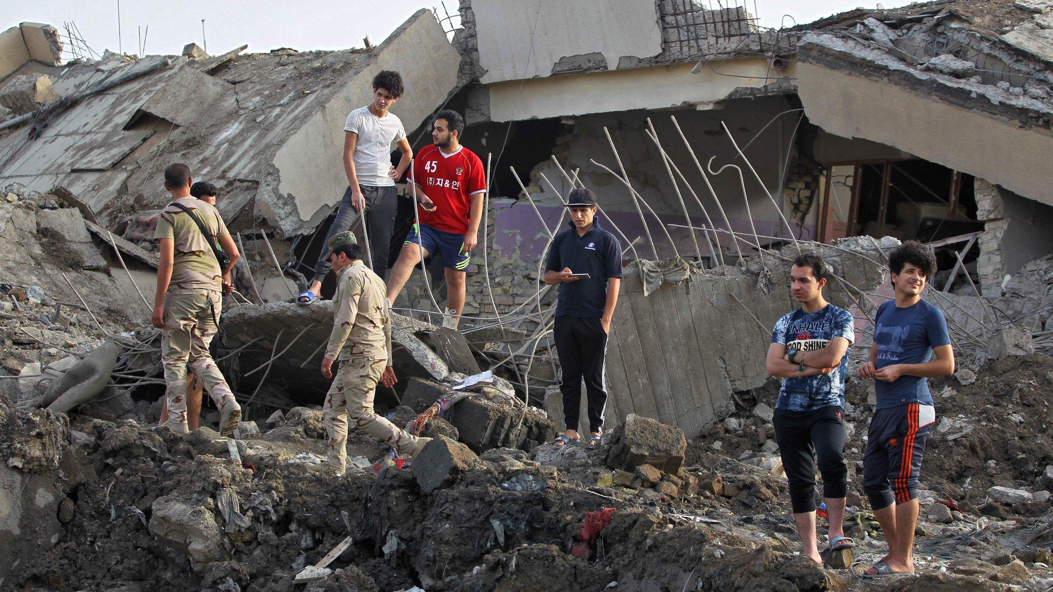 Iraqis inspect the aftermath of explosions that destroyed a mosque in Baghdad's Sadr City district (7 June 2018)