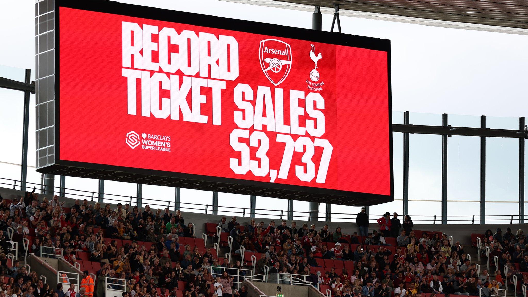 An LED board inside the stadium displays a message reading "record ticket sales"