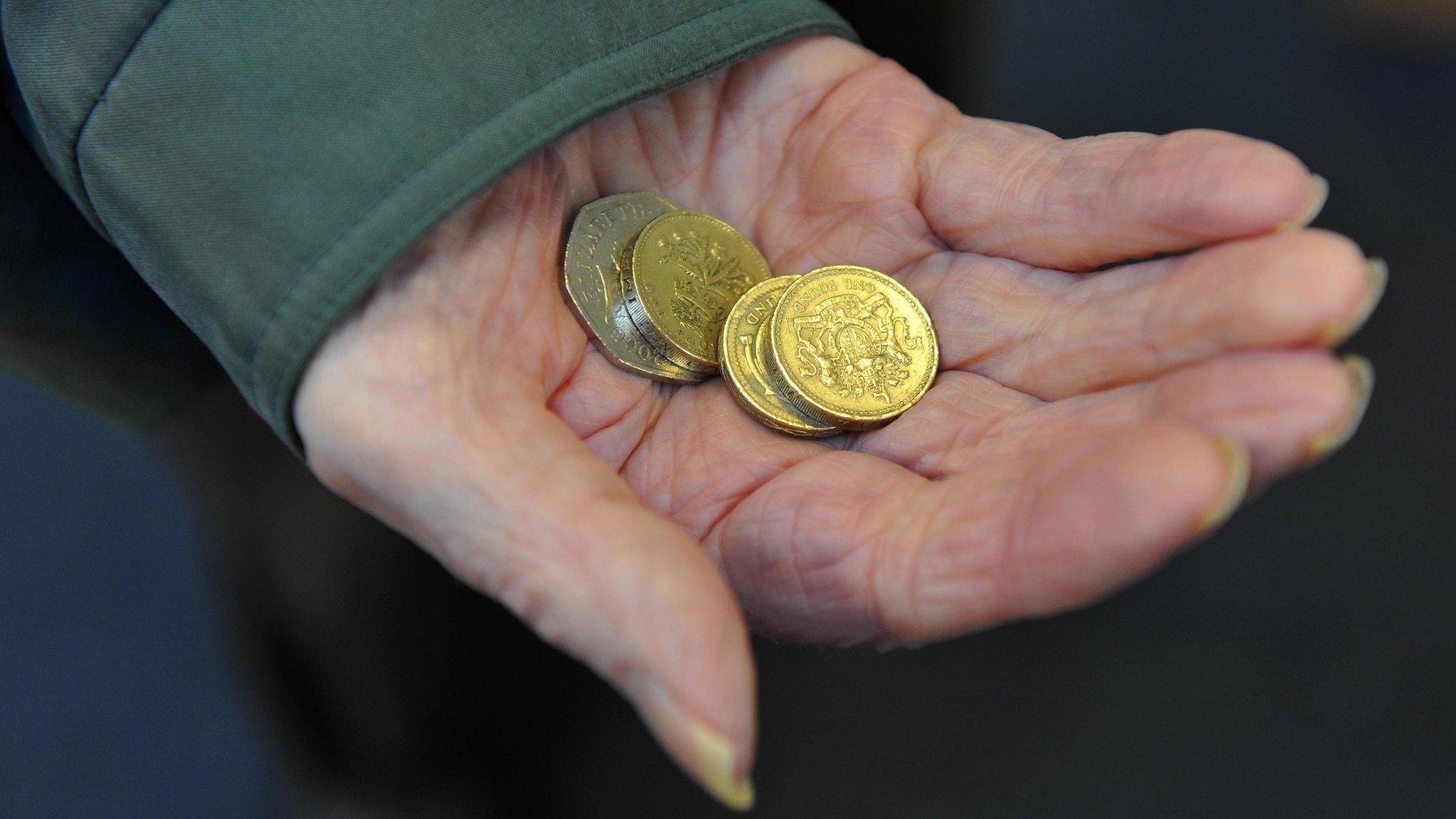 An elderly woman holding coins