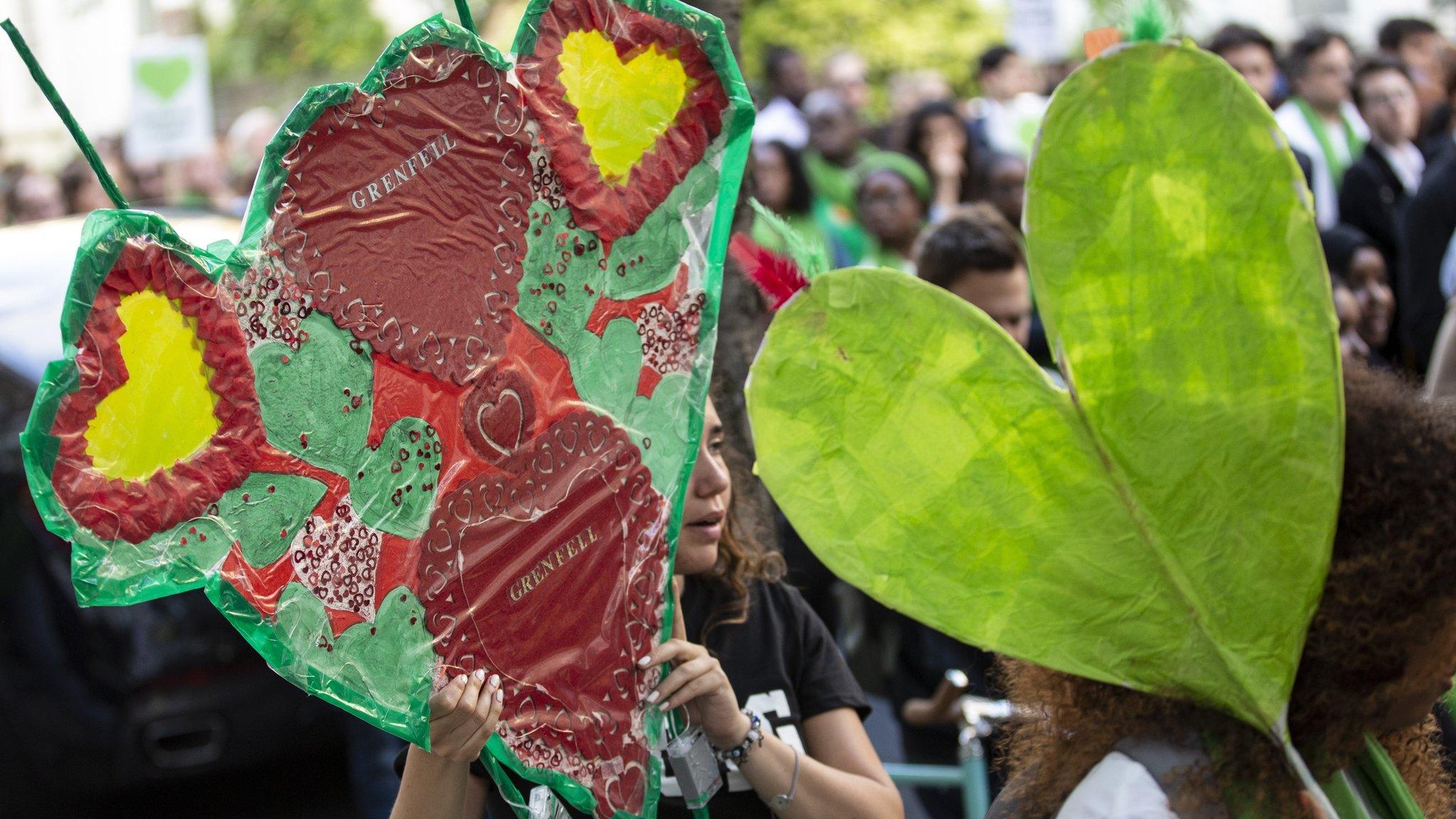 People attend a silent walk by Grenfell Tower on one-year anniversary