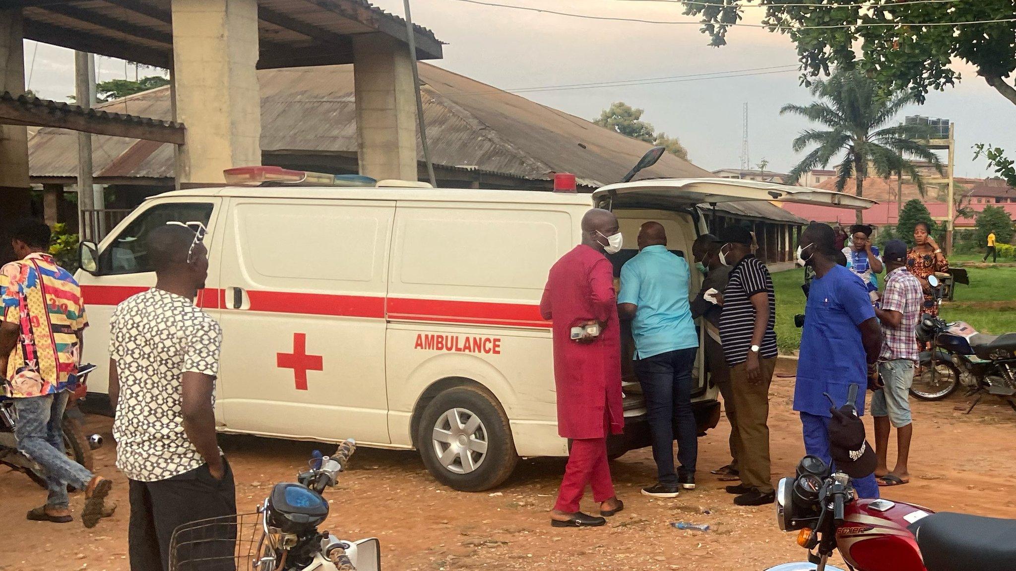 Relatives of churchgoers who were attacked by gunmen during Sunday"s church service gather as health workers attend to victims