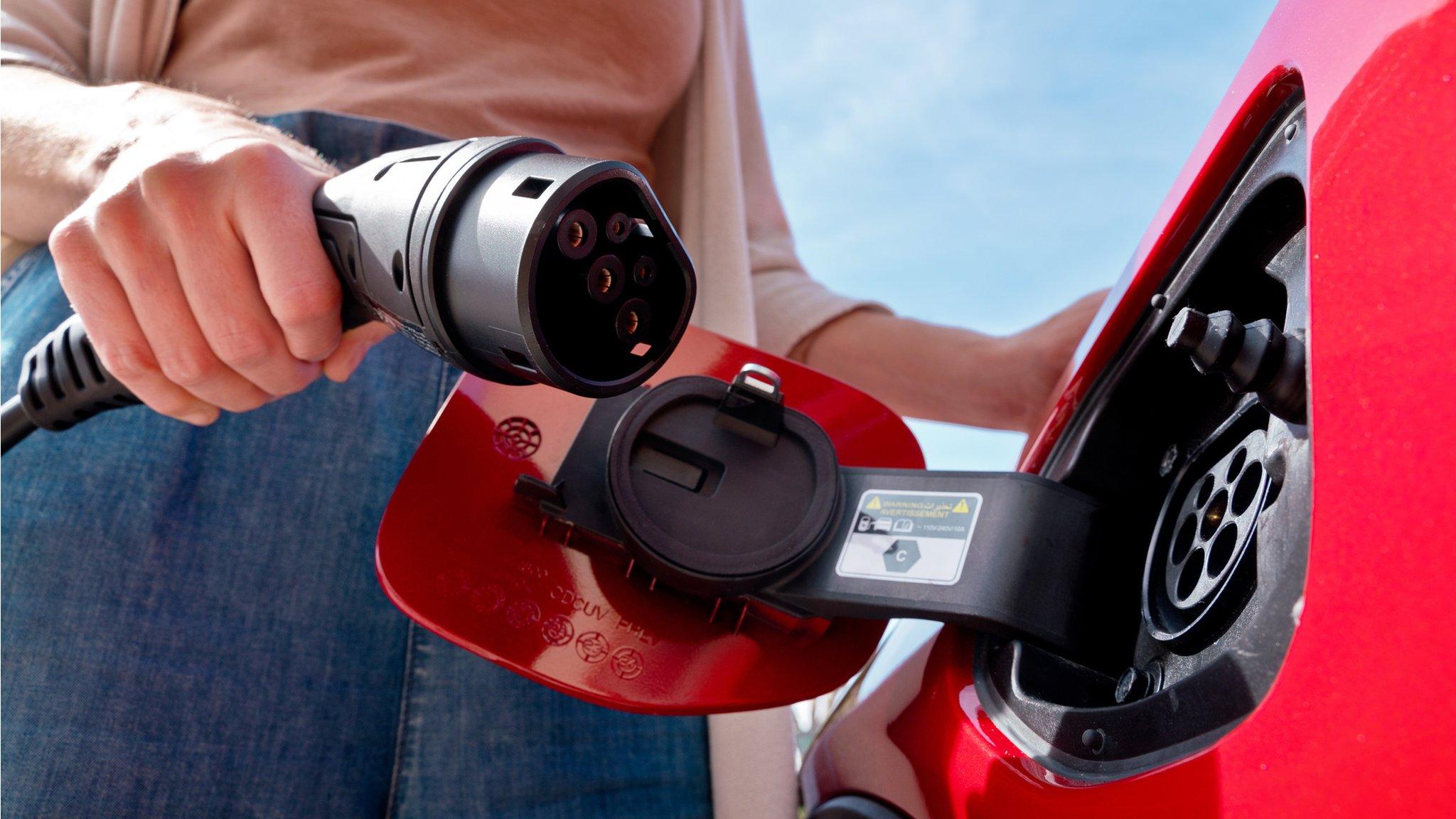 Woman charging electric car