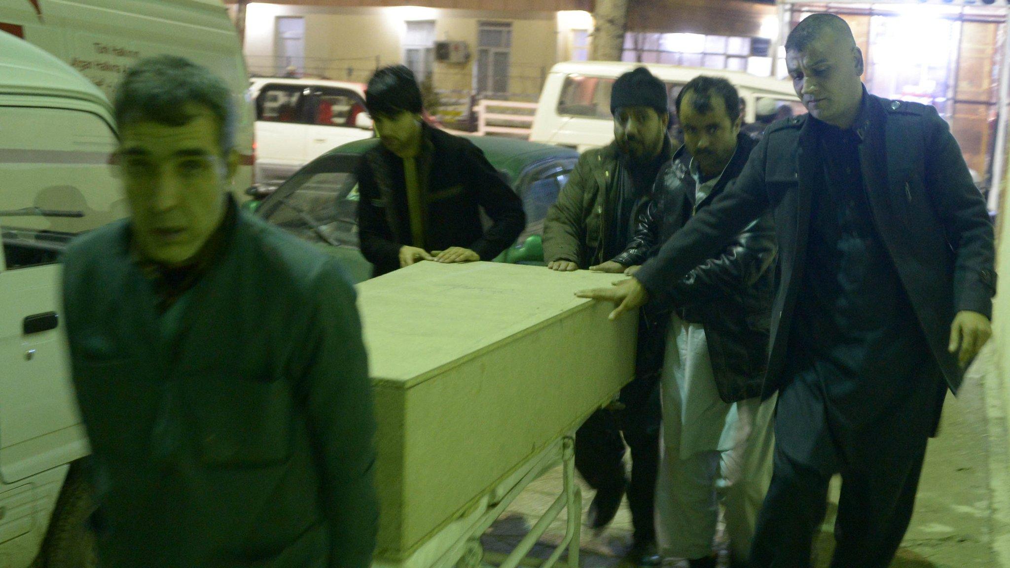 Men unload coffin of an ICRC employee killed by gunmen in Jowzjan province at a hospital in Mazar-i-Sharif, Afghanistan February 8, 2017