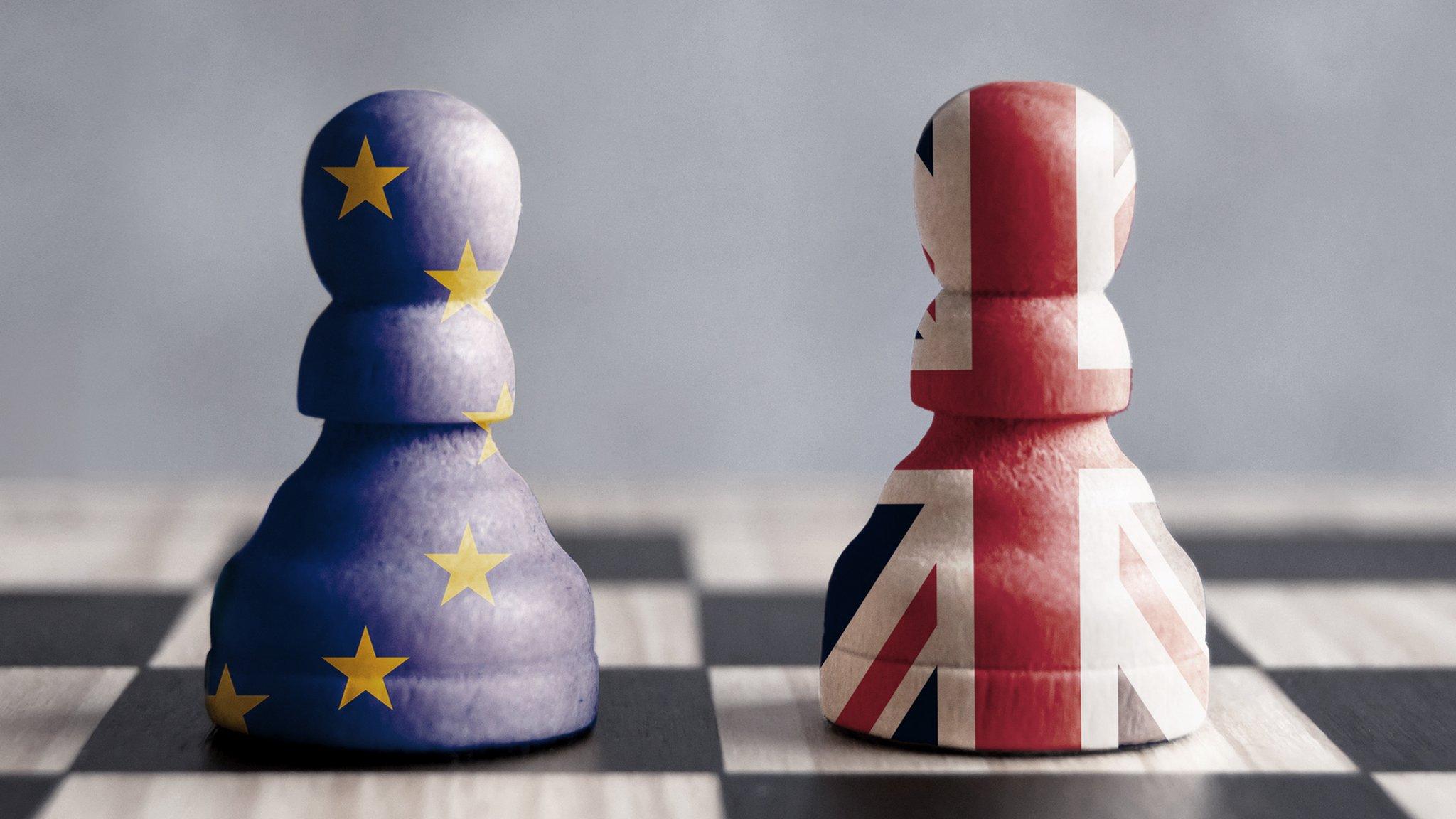 Two chess pawns with UK and European flags