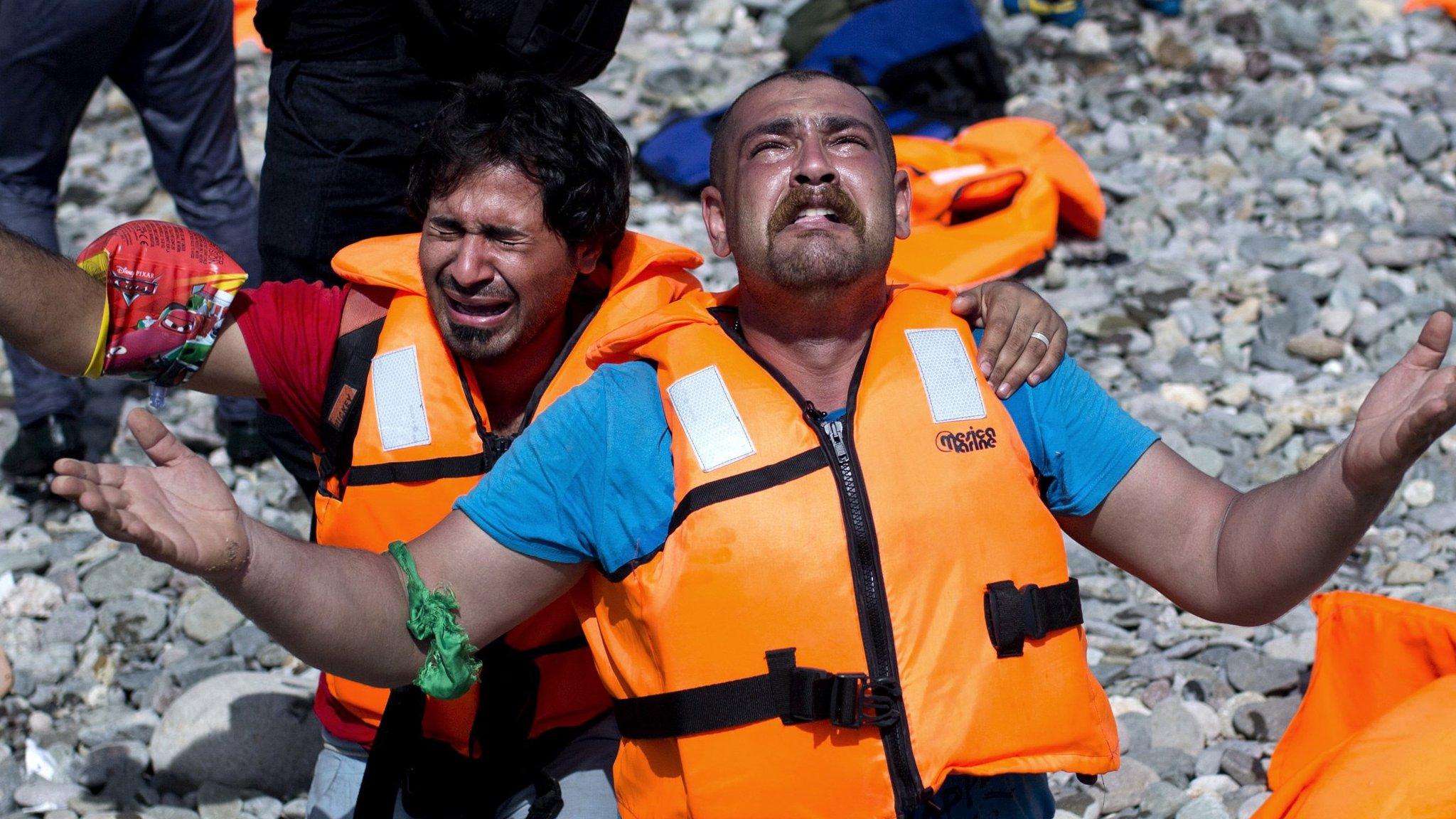 Refugees from Syria pray after arriving on the shores of the Greek island of Lesbos