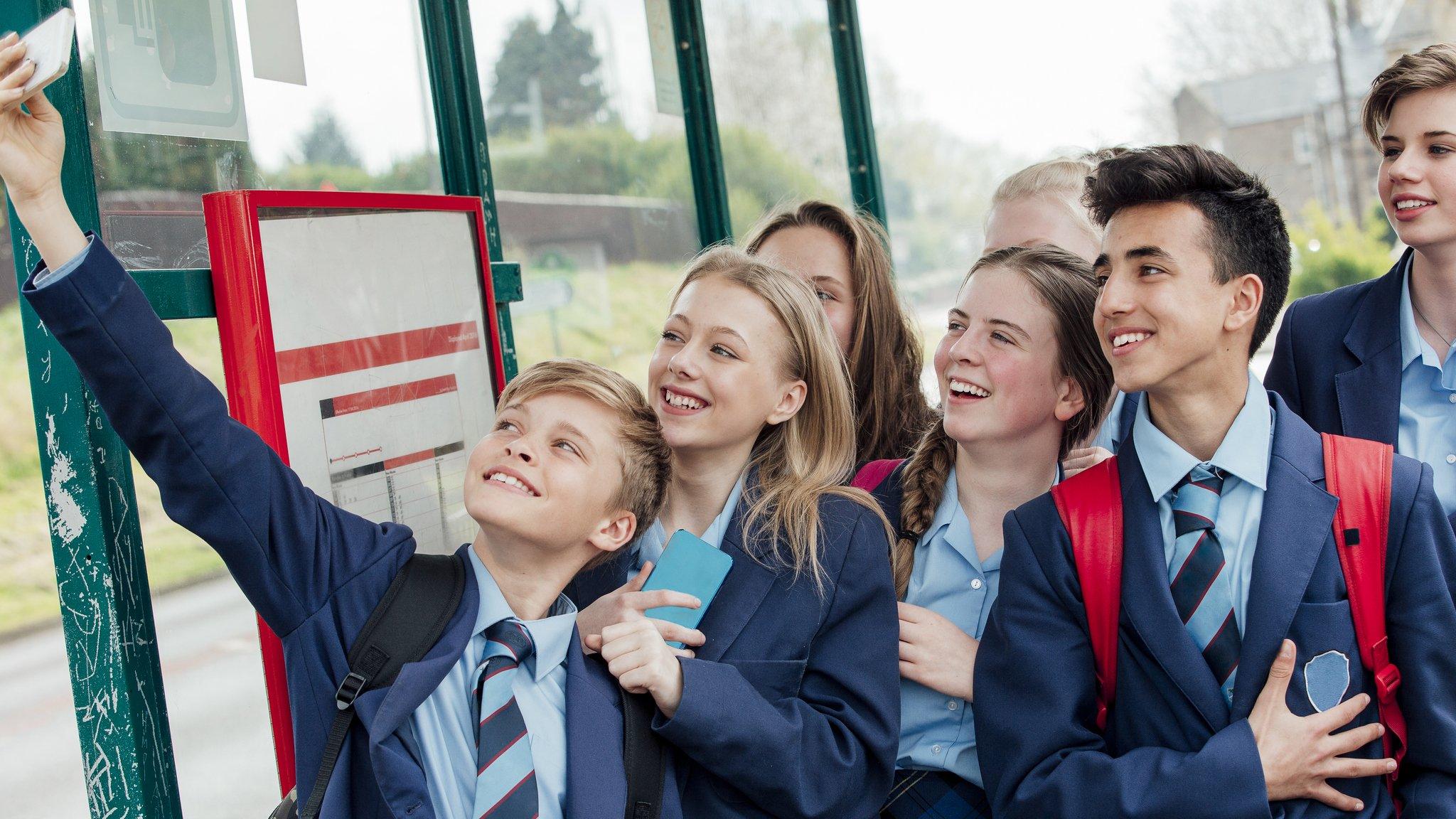 Students taking a picture on a phone.