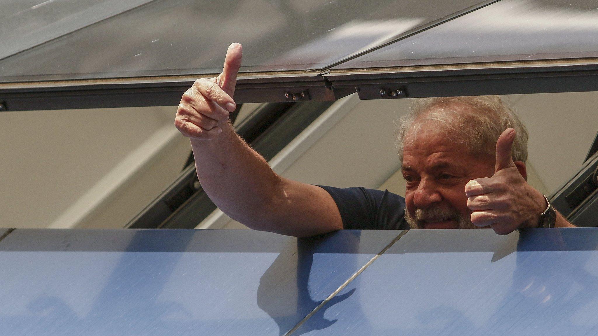 Former President Lula gestures from prison window