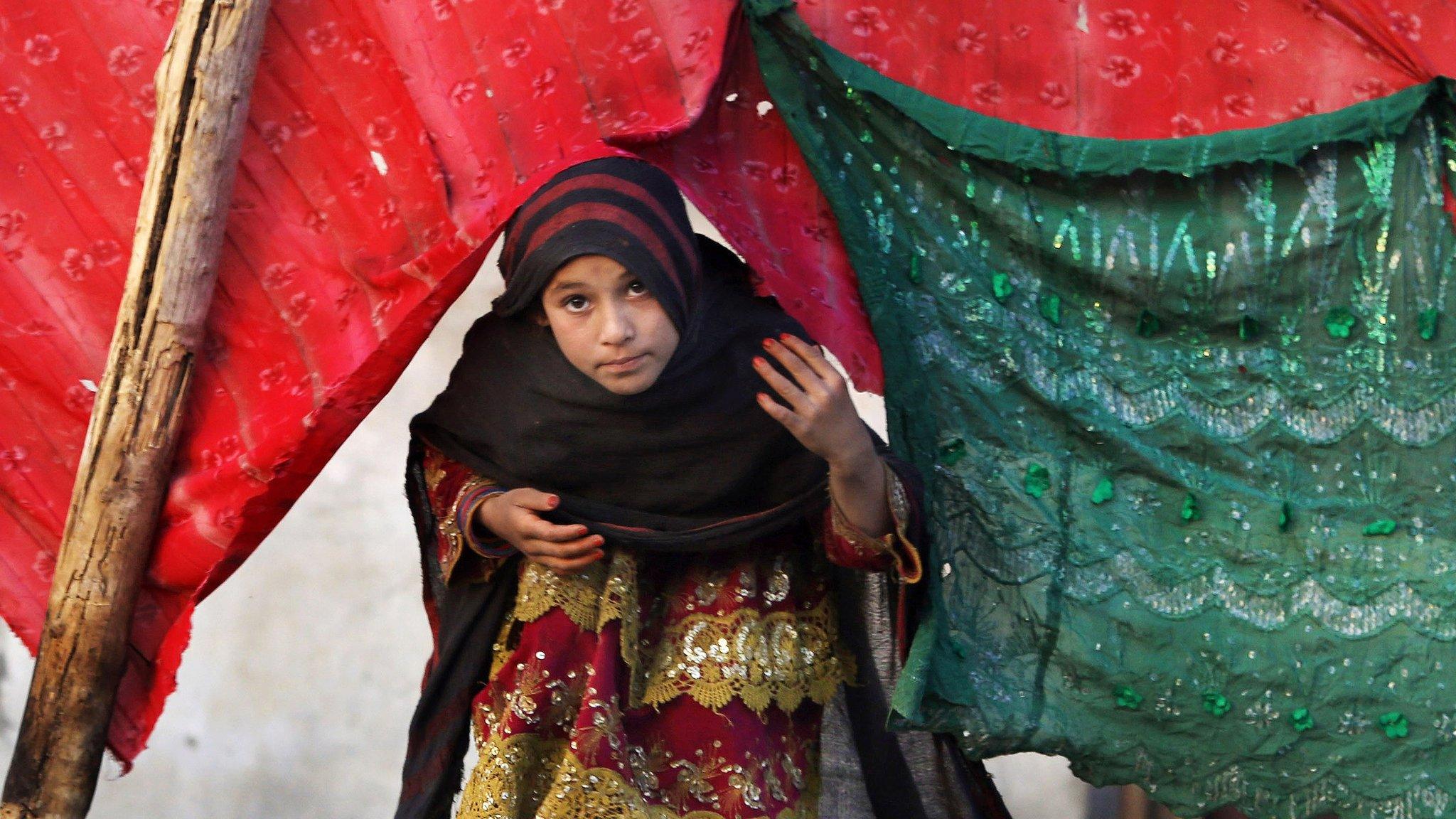 File photo: An internally displaced girl peeks from a tent after her family left their village in Rodat district of Jalalabad east of Kabul, Afghanistan, 29 November 2015